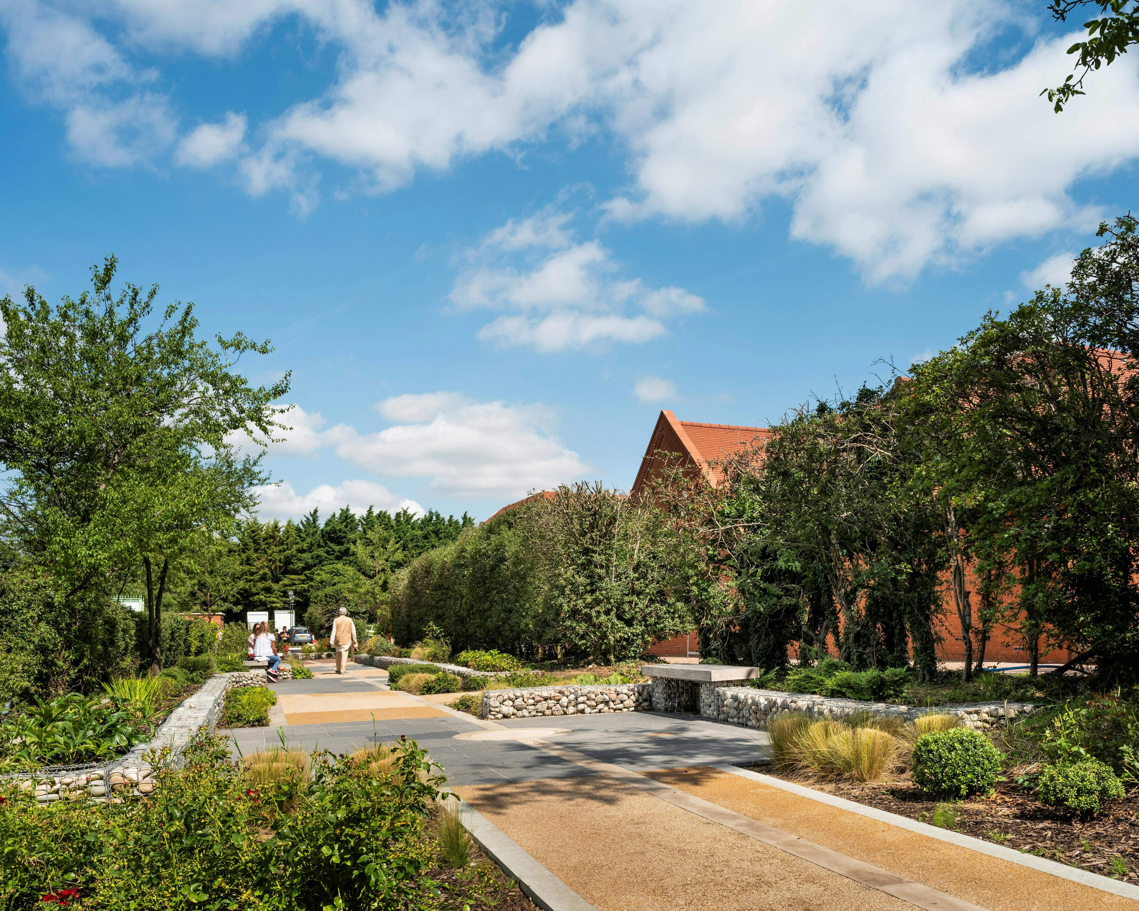 A tree lined walkway by a Hindu Temple with green oak framed veranda