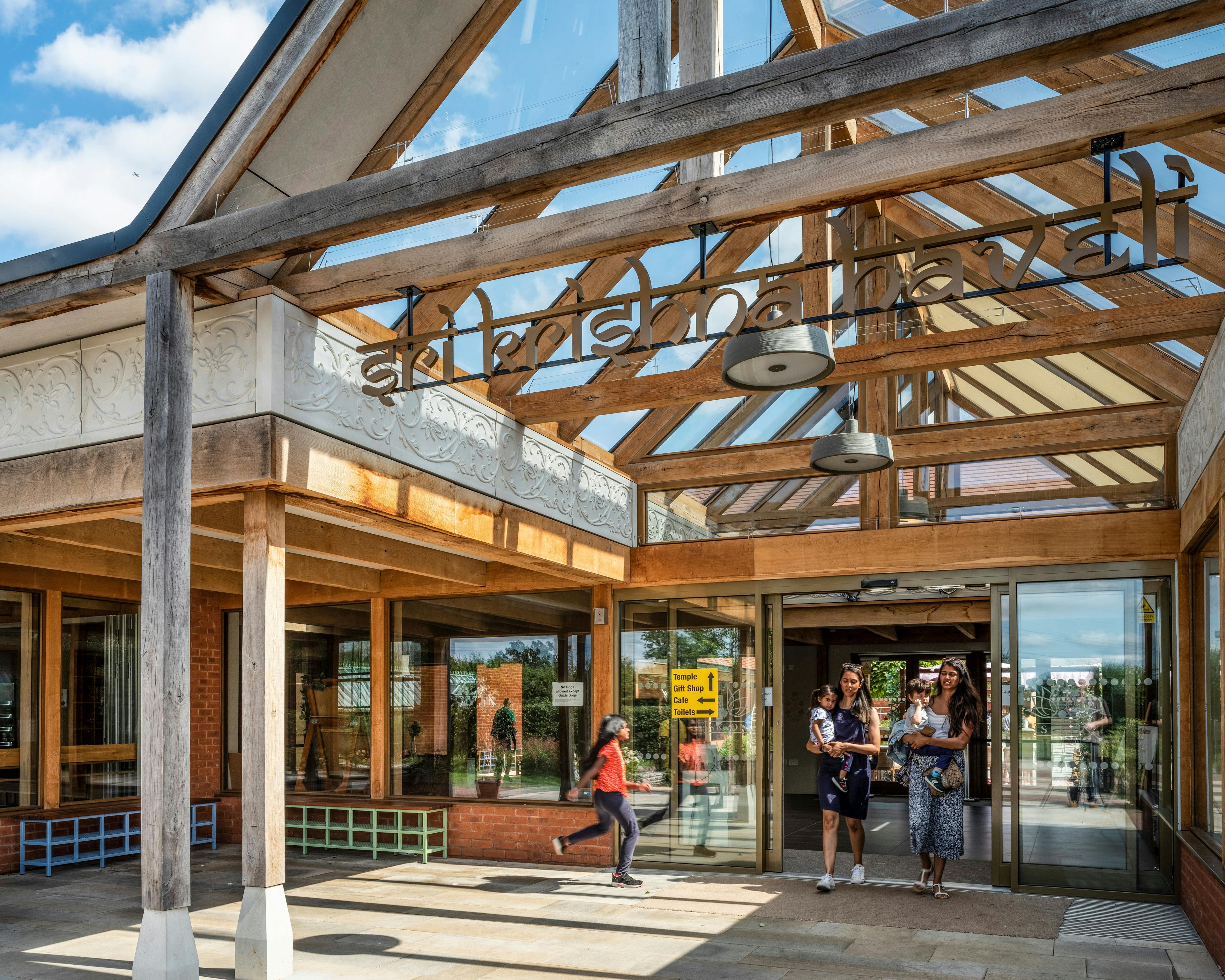 A green oak framed entranceway with a glazed vaulted ceiling of a Hindu Temple