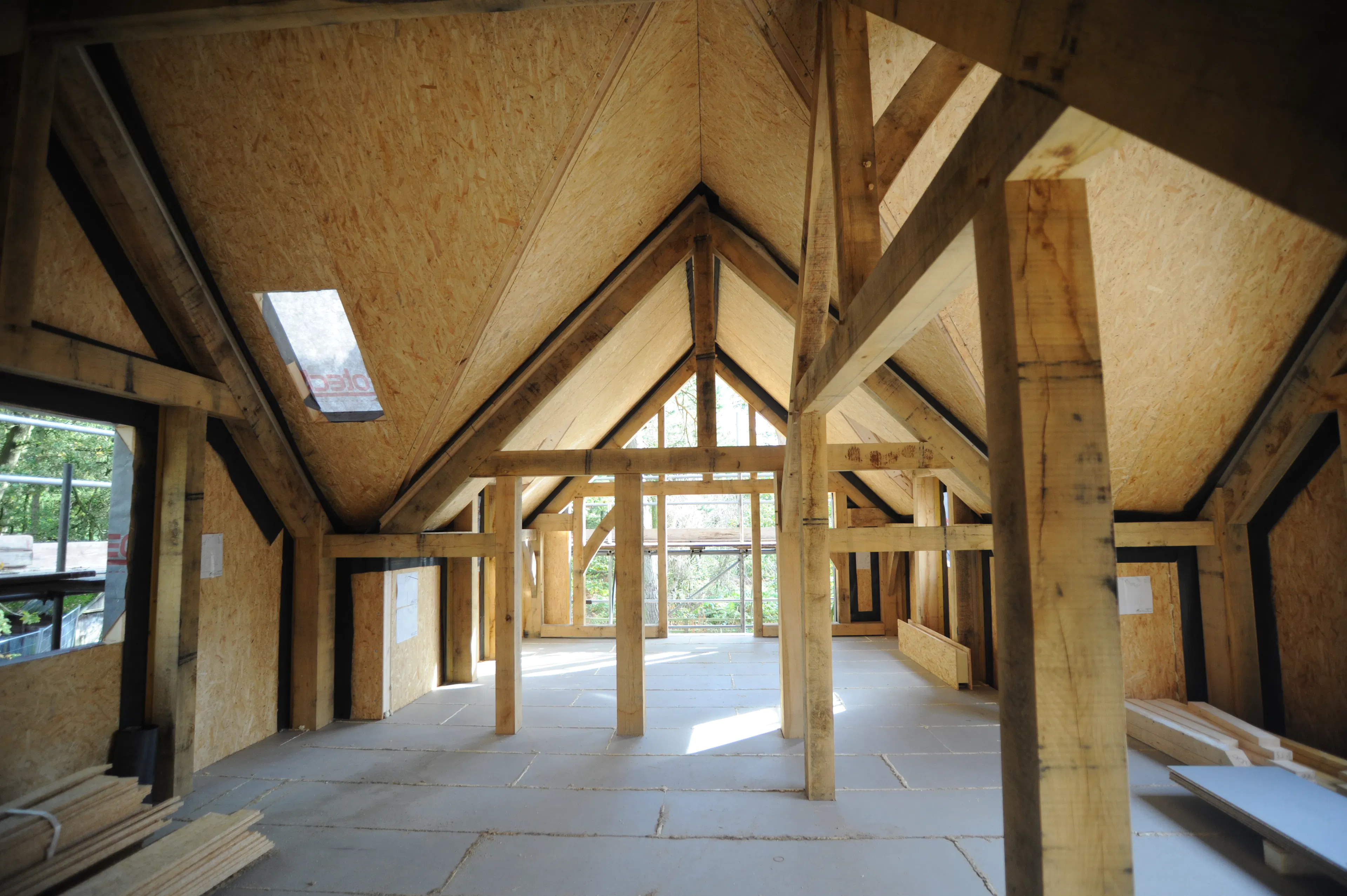 Encapsulation and insulation being installed on the top floor of the oak frame at Higham Findlow site
