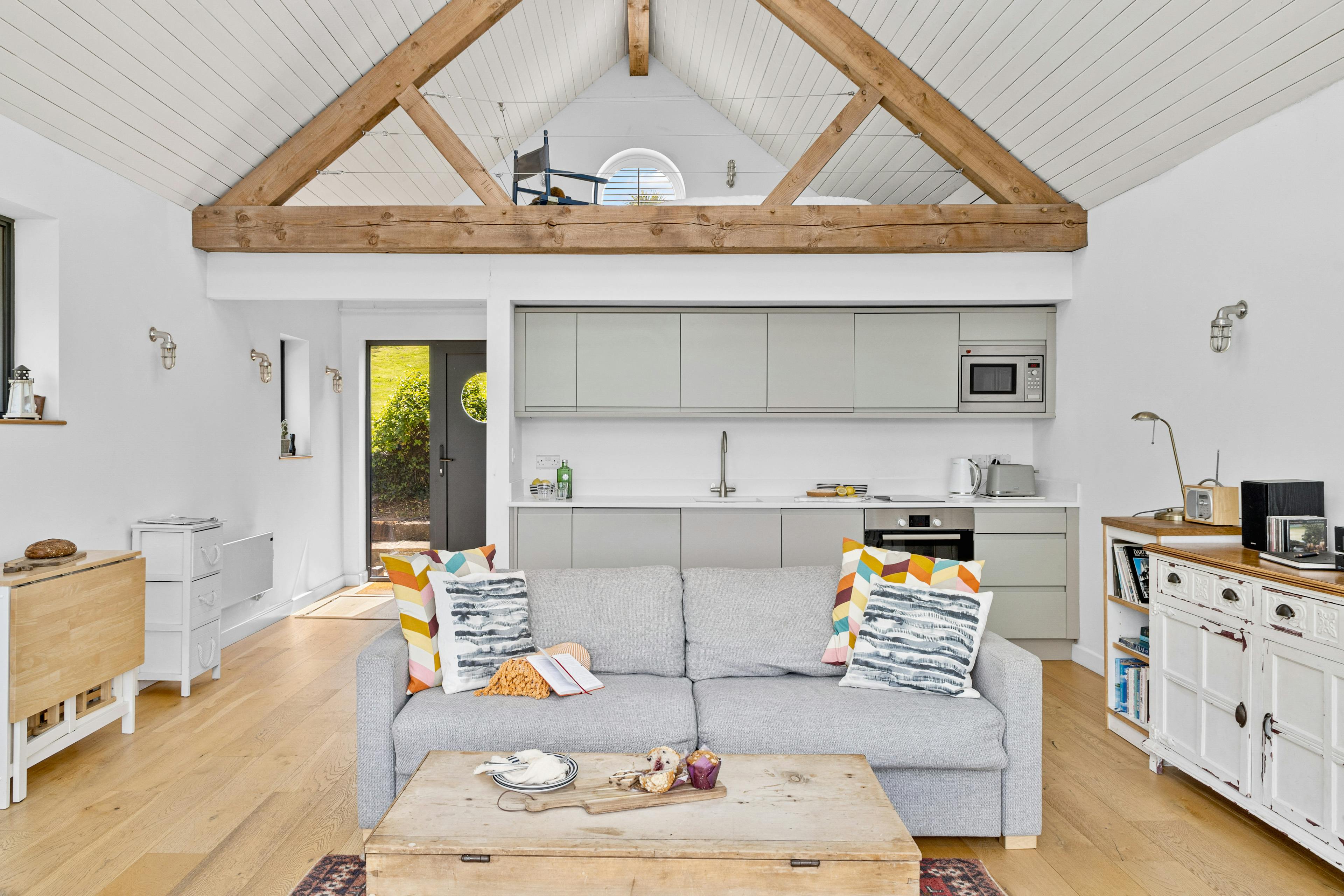 The open plan living room and kitchen of an oak framed boathouse 
