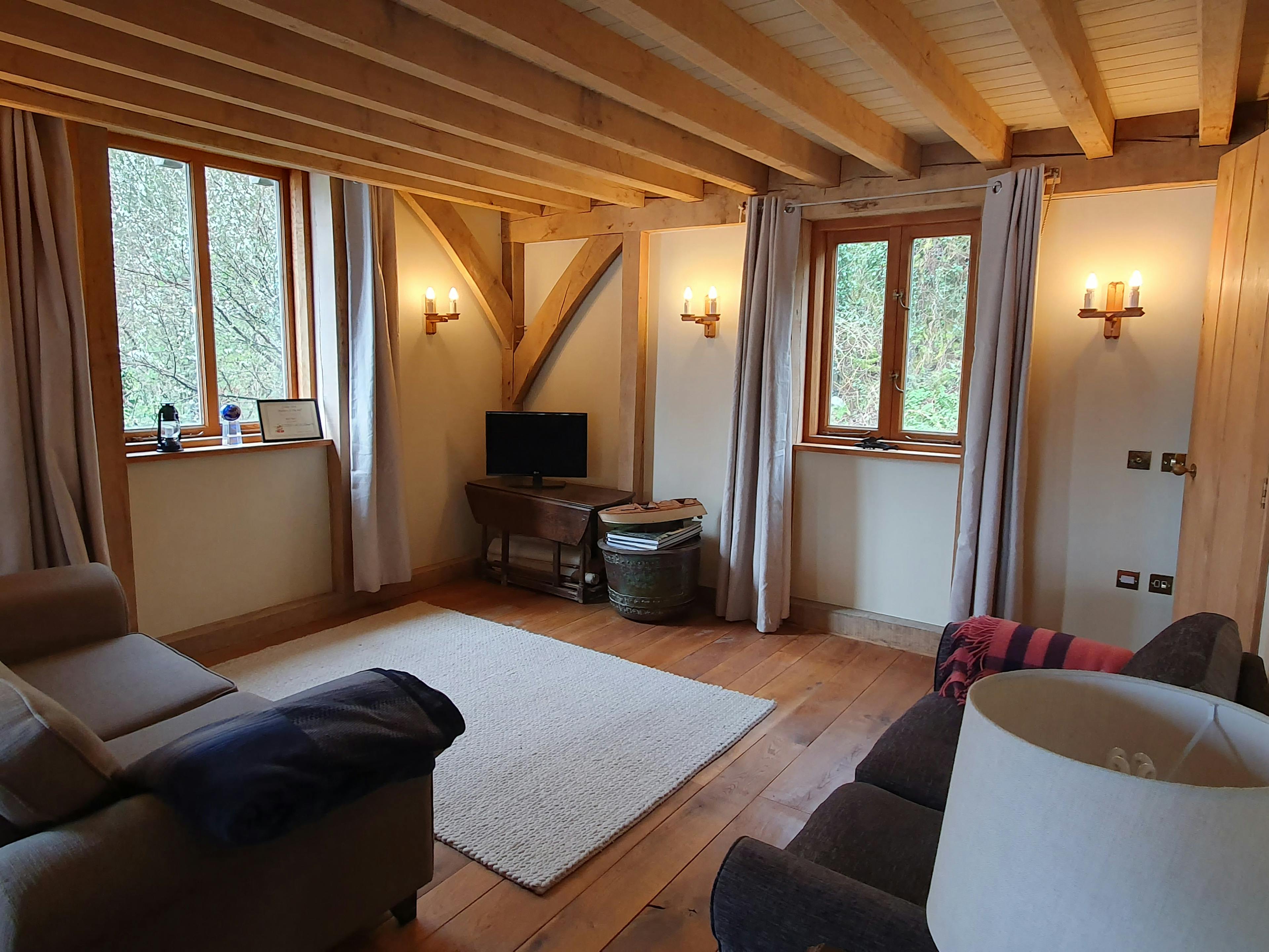 A lounge with sofas in an oak framed boathouse 