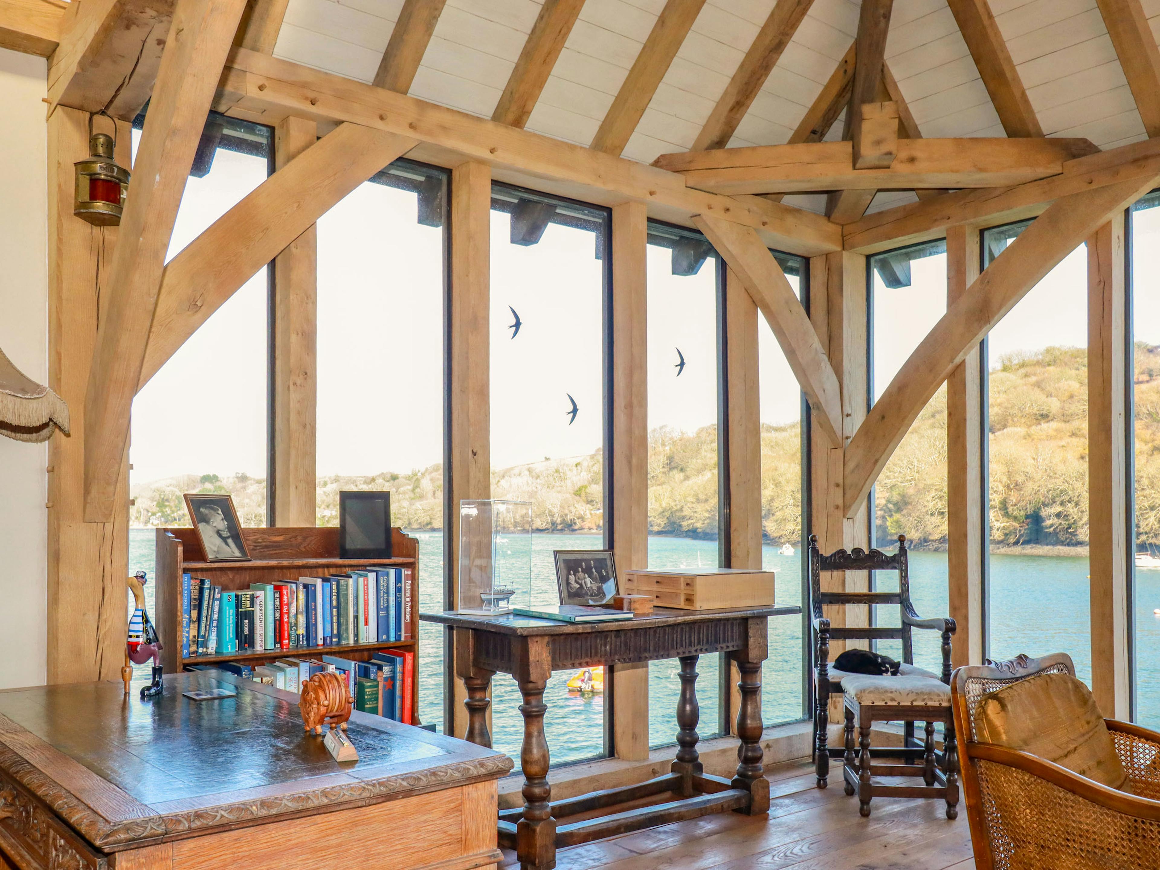 The sitting area with glazed windows provide views of the River Fowey from an oak framed boathouse 