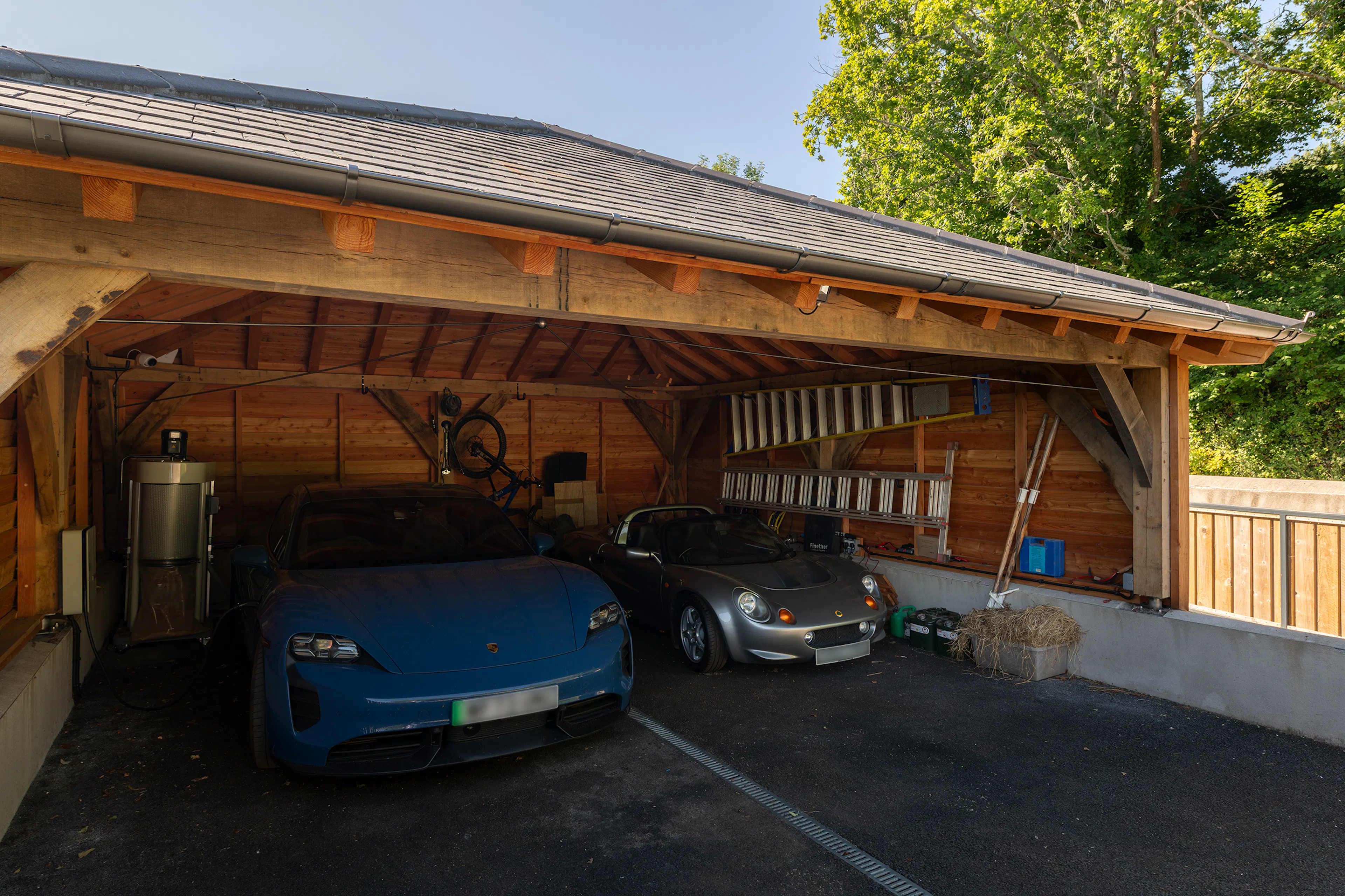 Two sports cars inside an oak framed garage