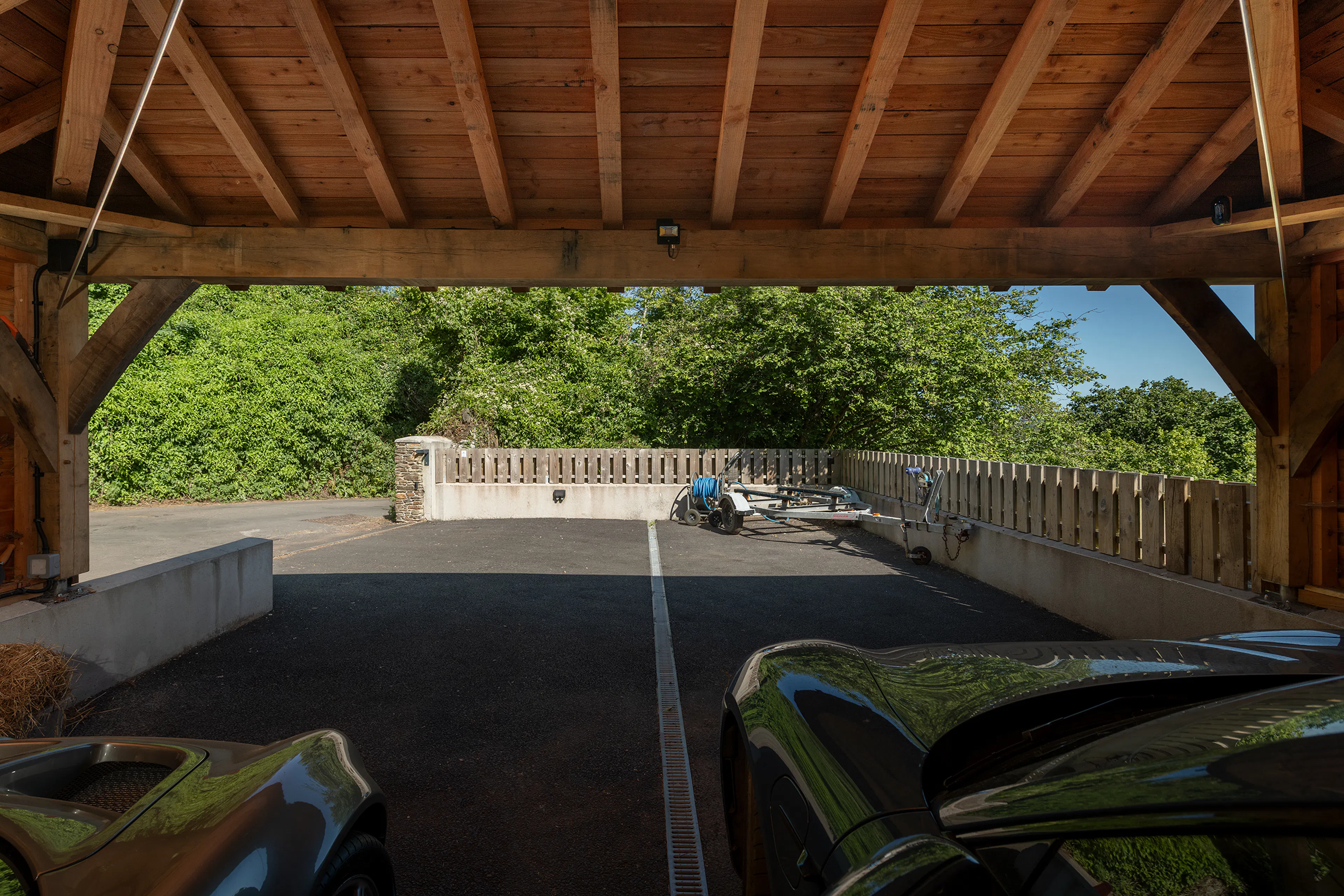 Two sports cars inside an oak framed garage 