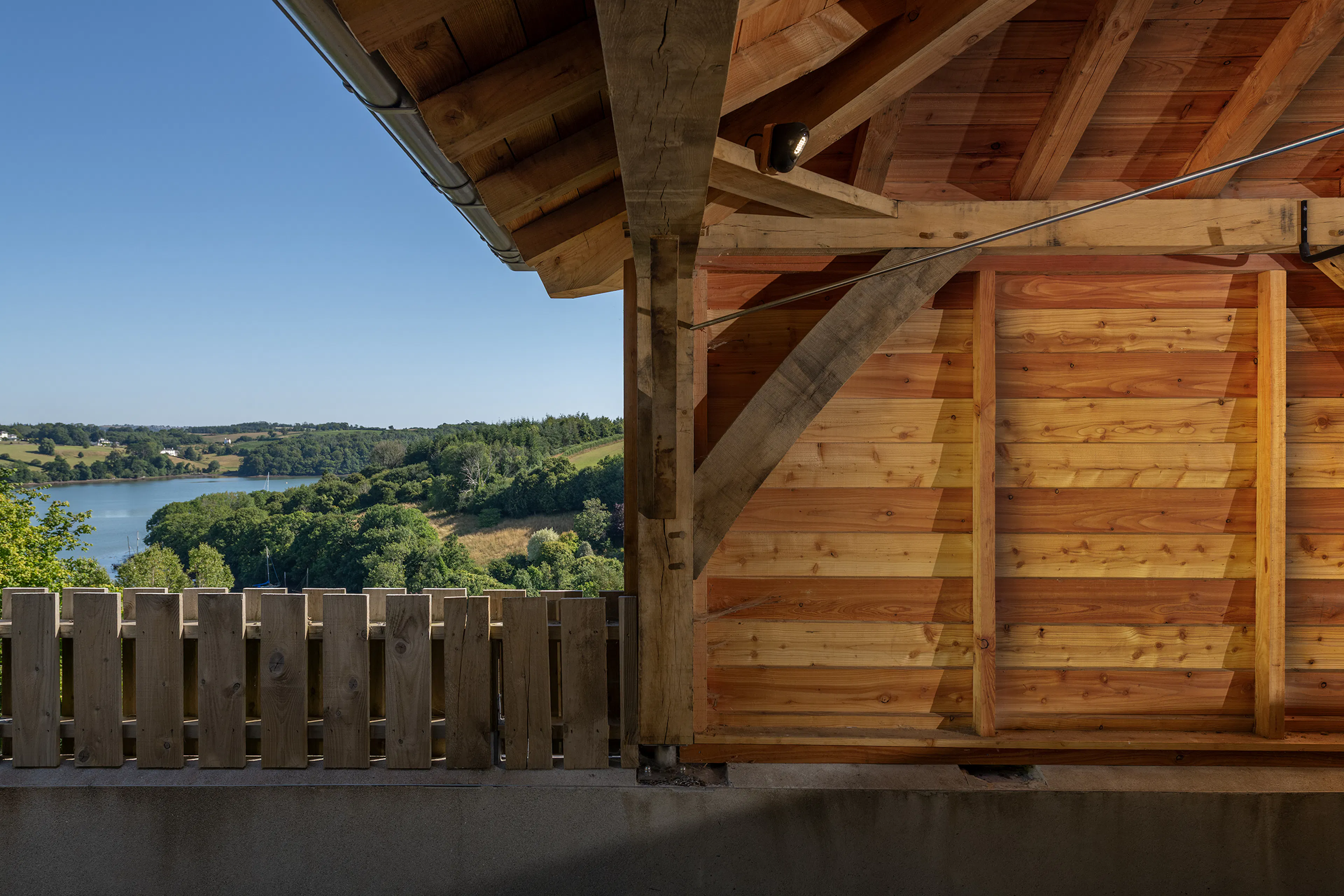 An oak framed garage with views of a river and green hills
