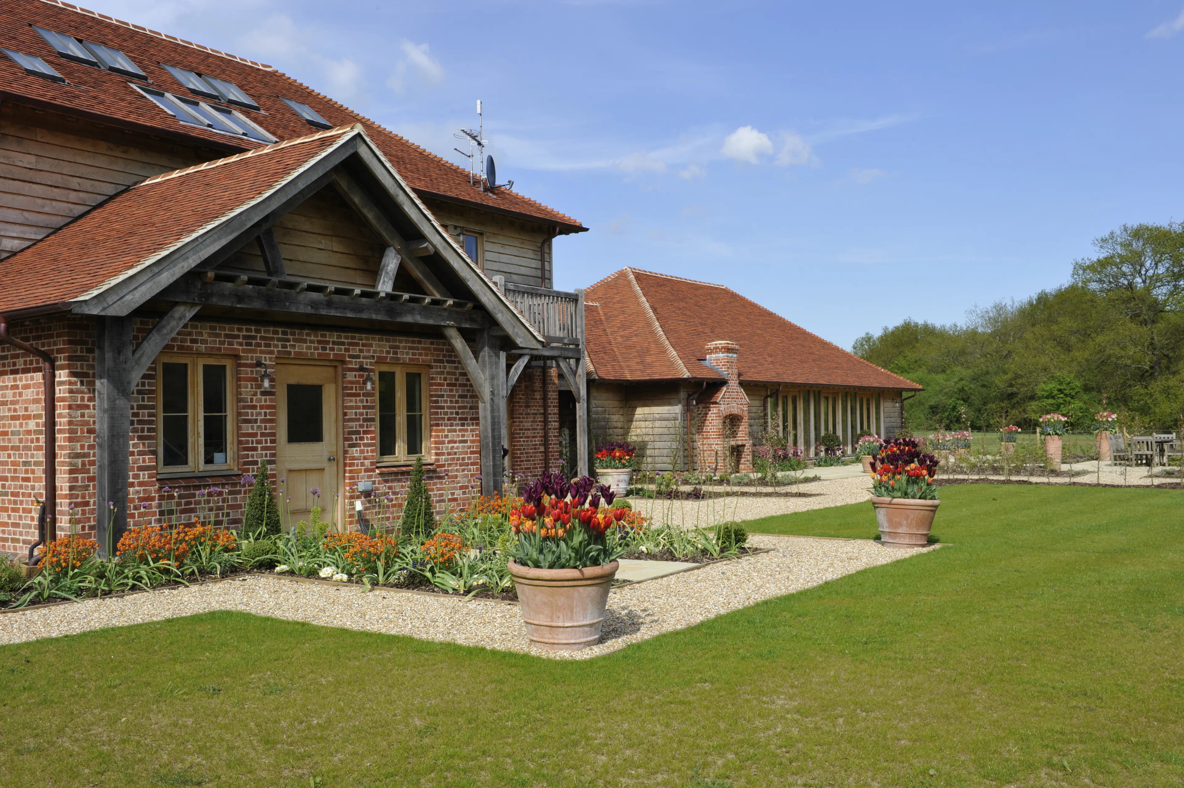 Exterior view of an expansive oak-framed family home with oak frame porch, balconies, and landscaped gardens