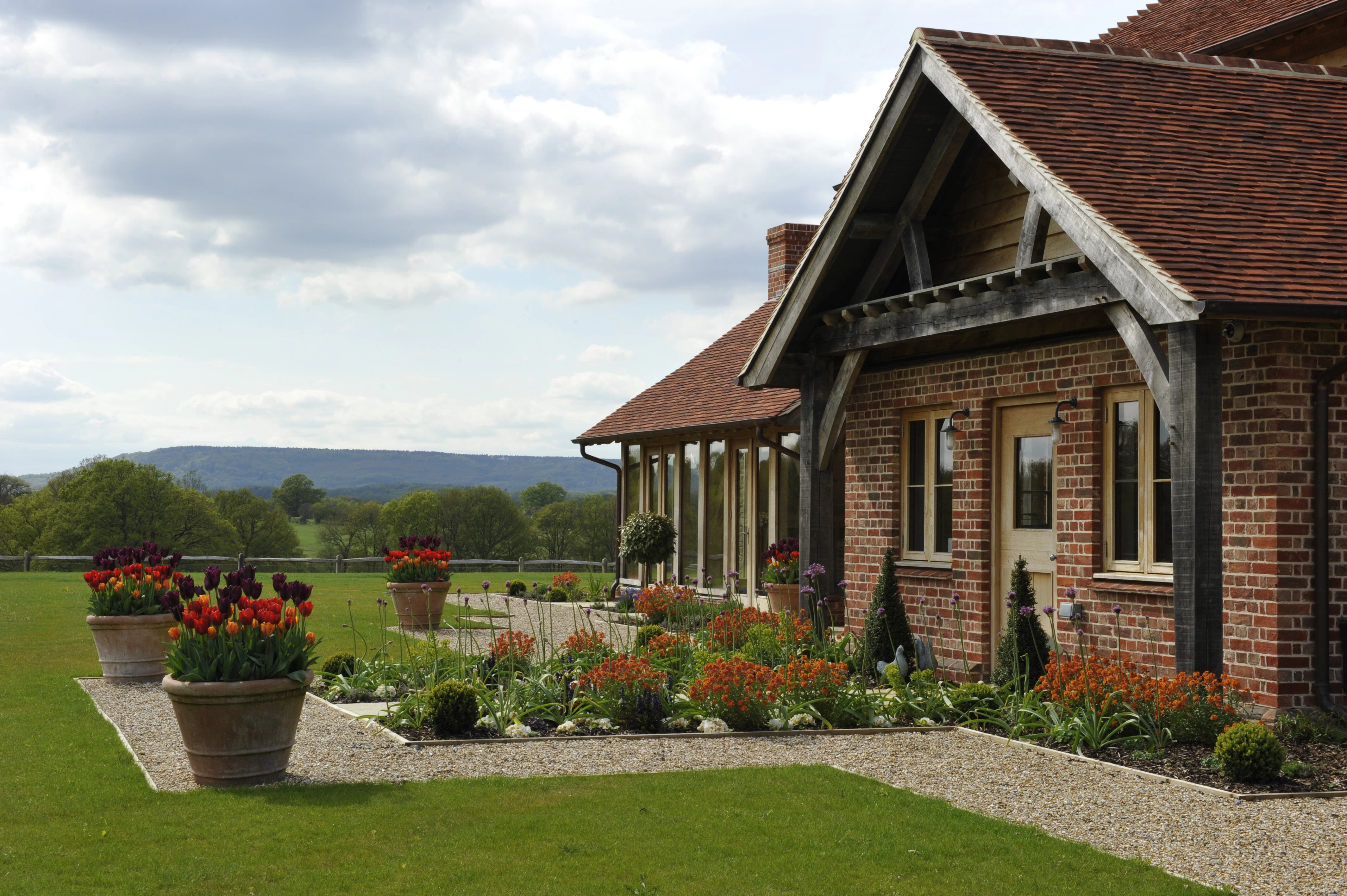 Exterior view of an expansive oak-framed family home with oak frame porch and landscaped gardens