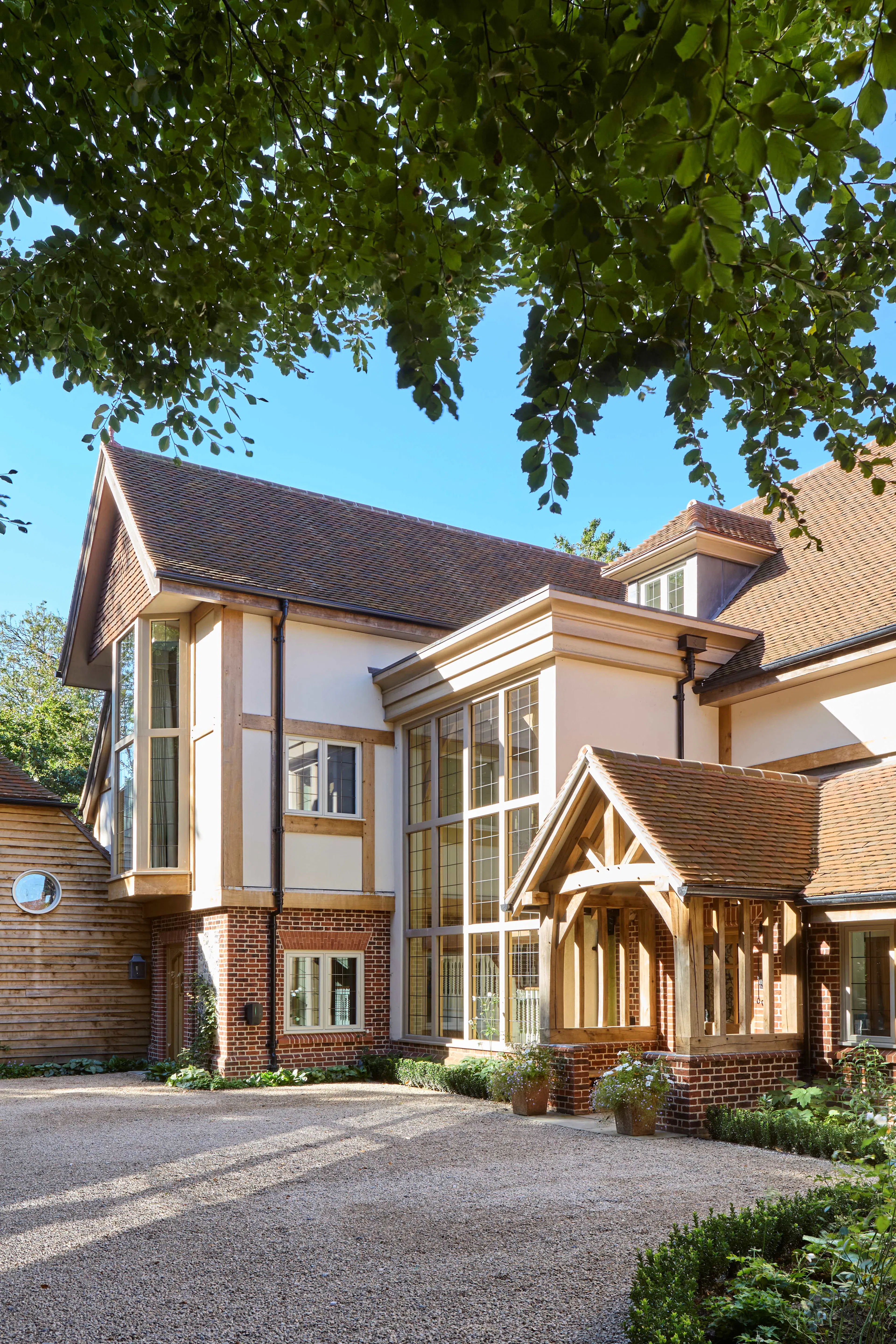 The front of a large 6 bedroom oak framed home with a double height glazed stairwell