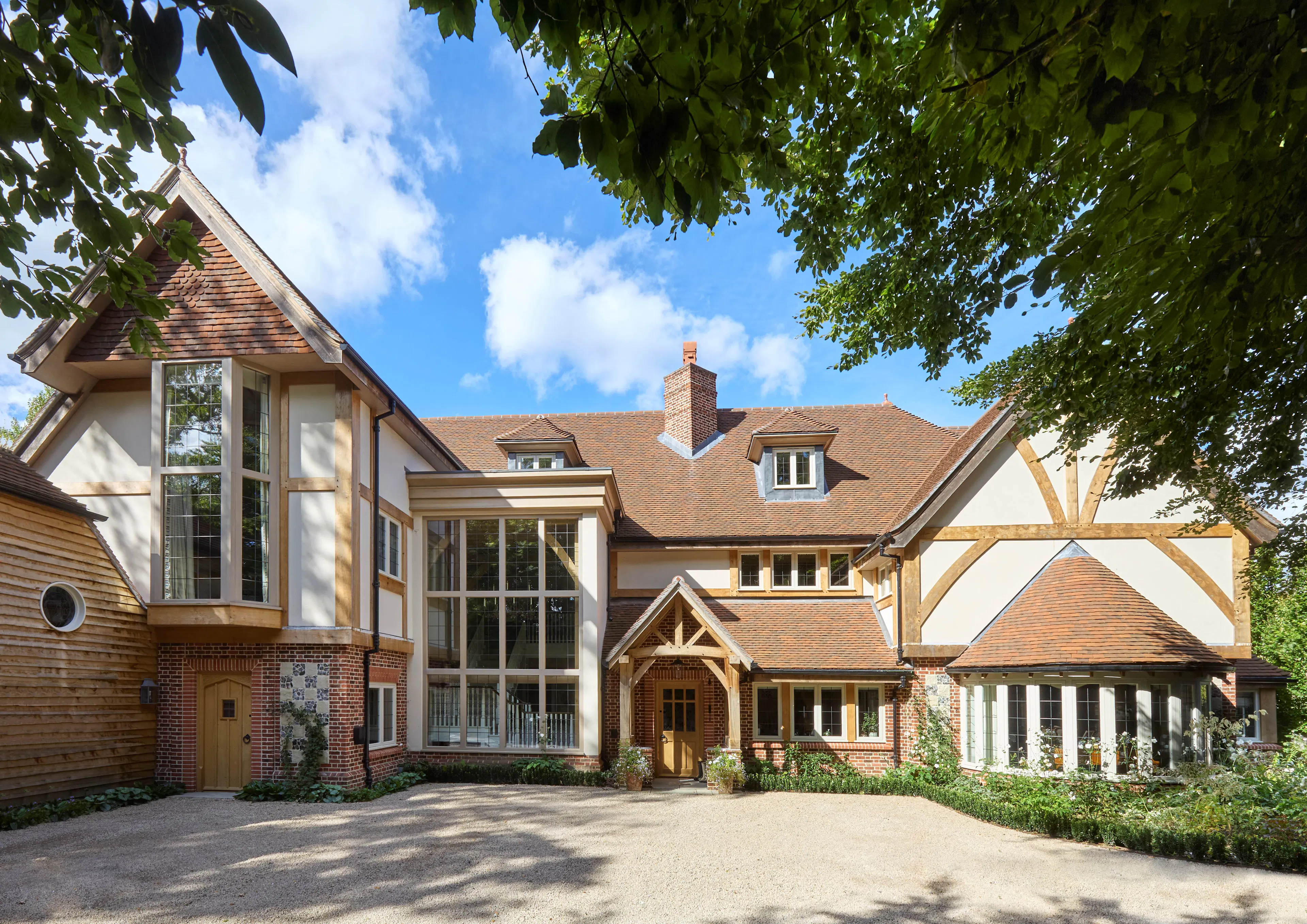 The front of a large 6 bedroom oak framed home with a double height glazed stairwell