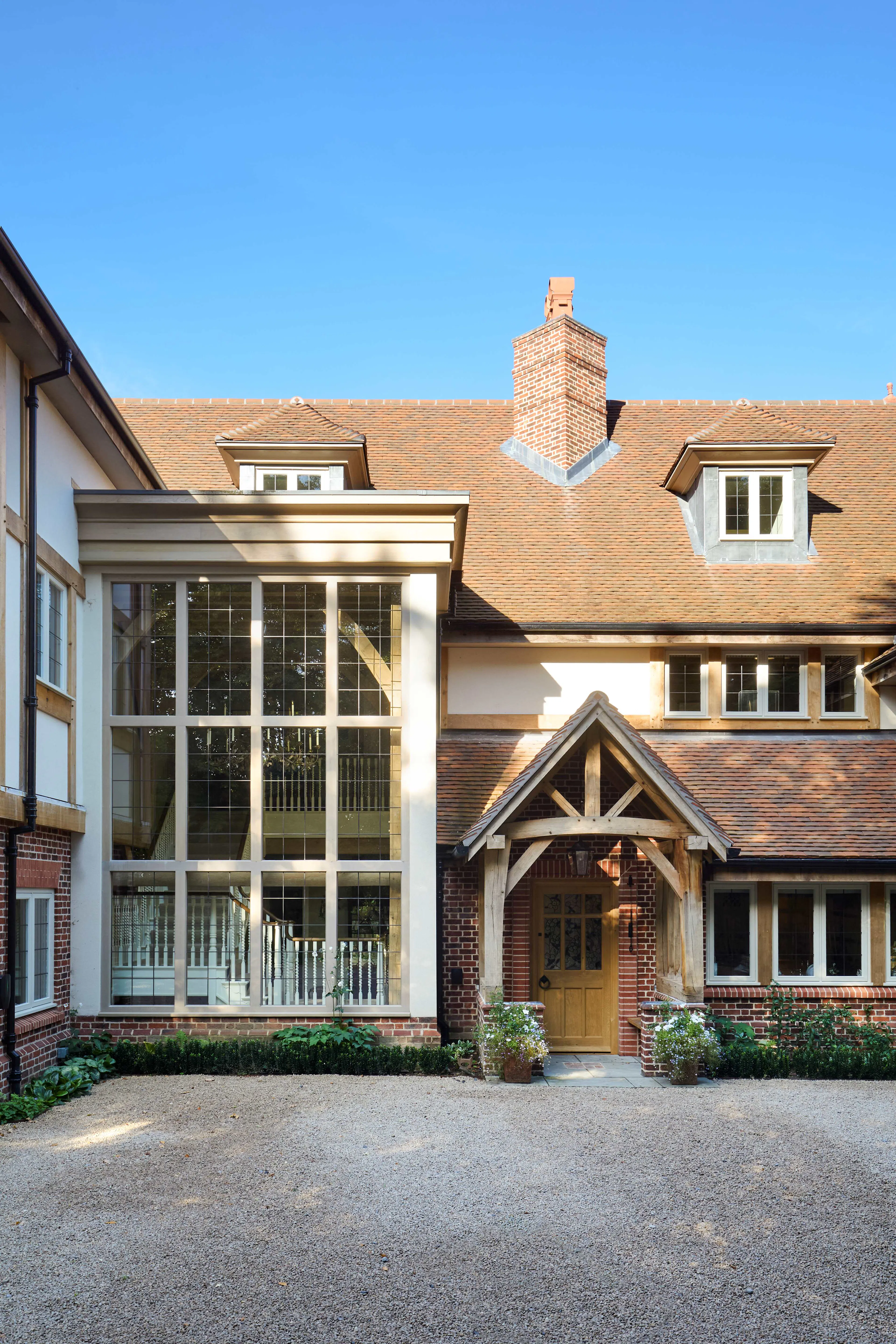 The front of a large 6 bedroom oak framed home with a double height glazed stairwell