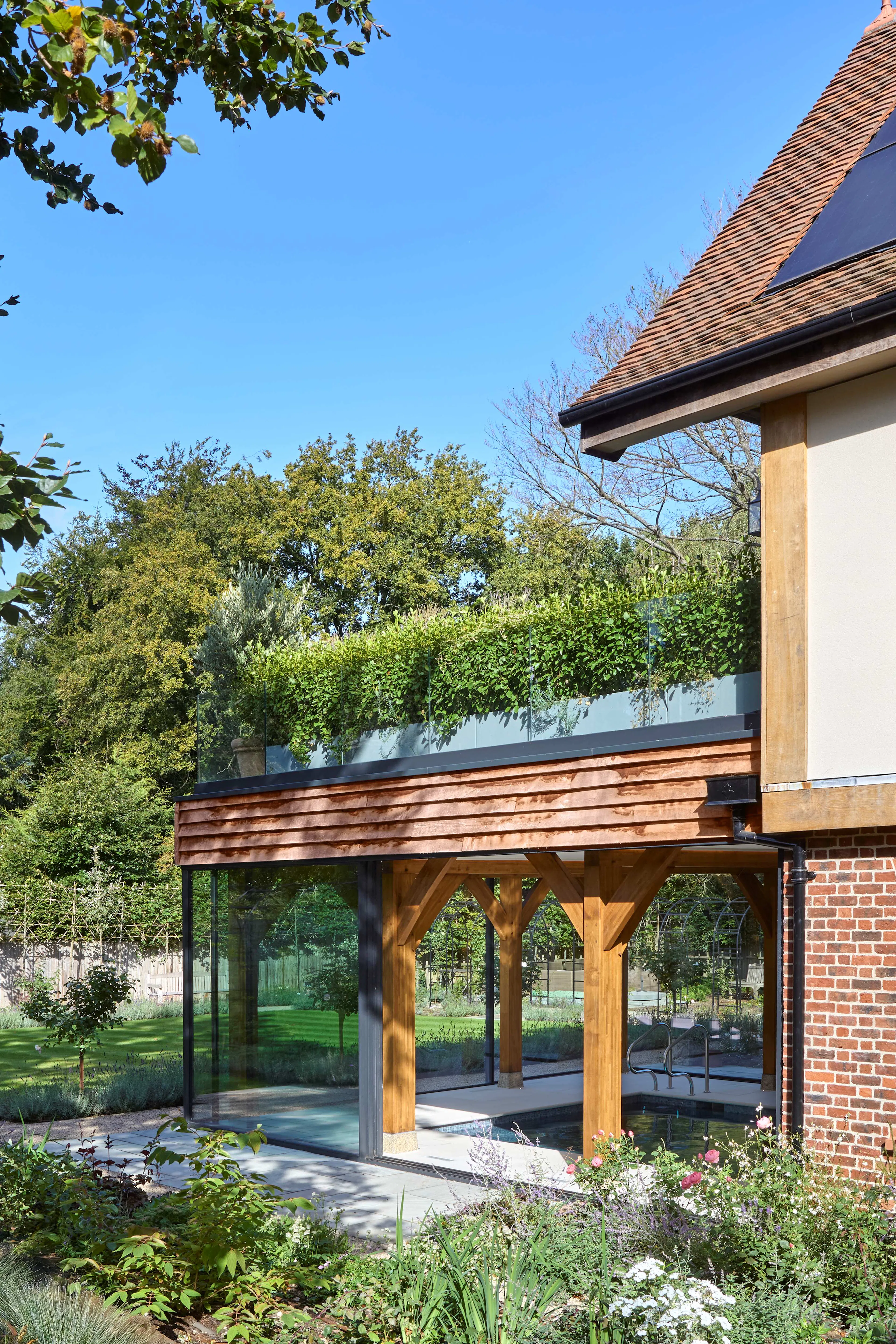 The rear of a large 6 bedroom oak framed home with a glazed swimming pool room
