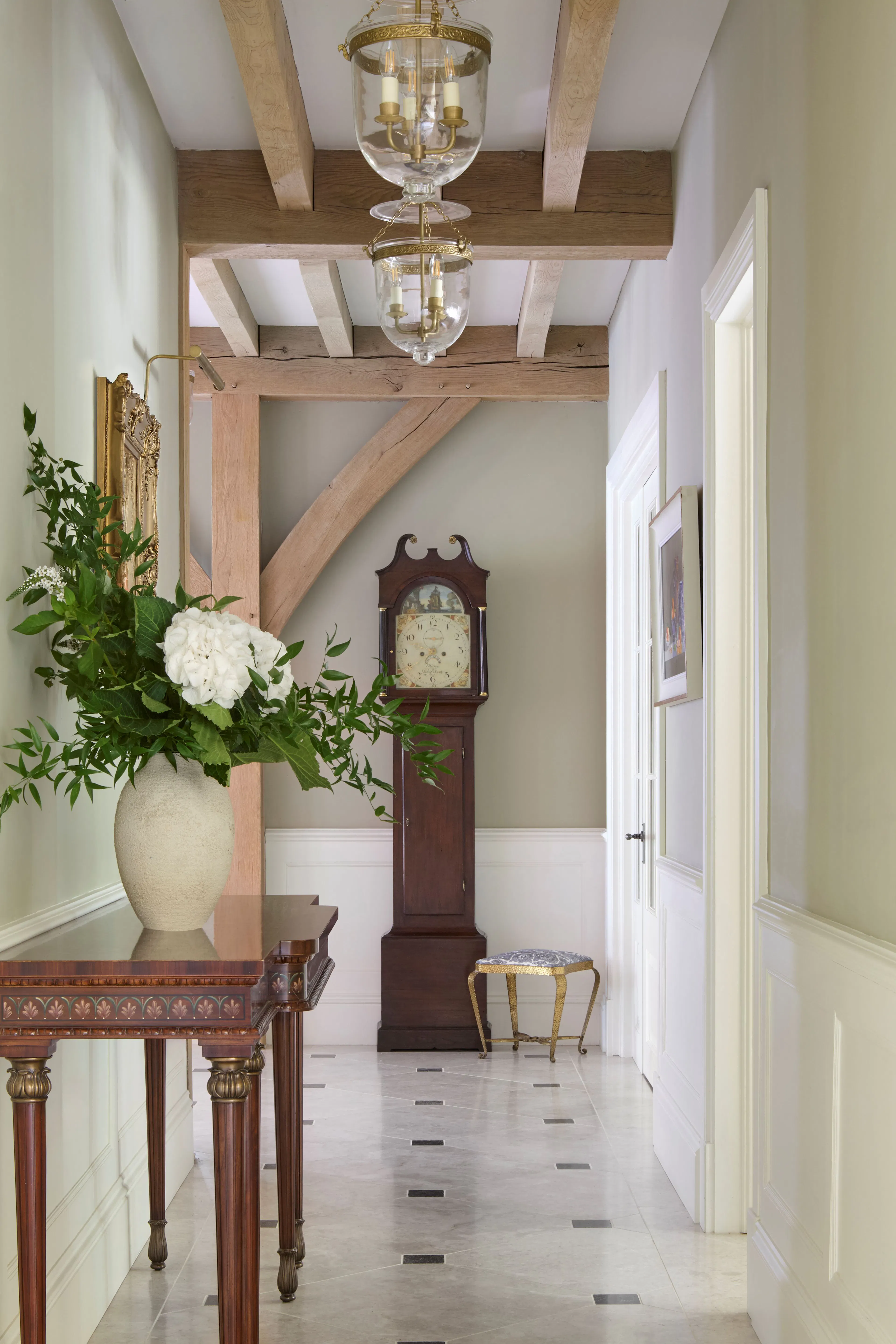 A hallway with a grandfather clock in a large 6 bedroom oak framed home