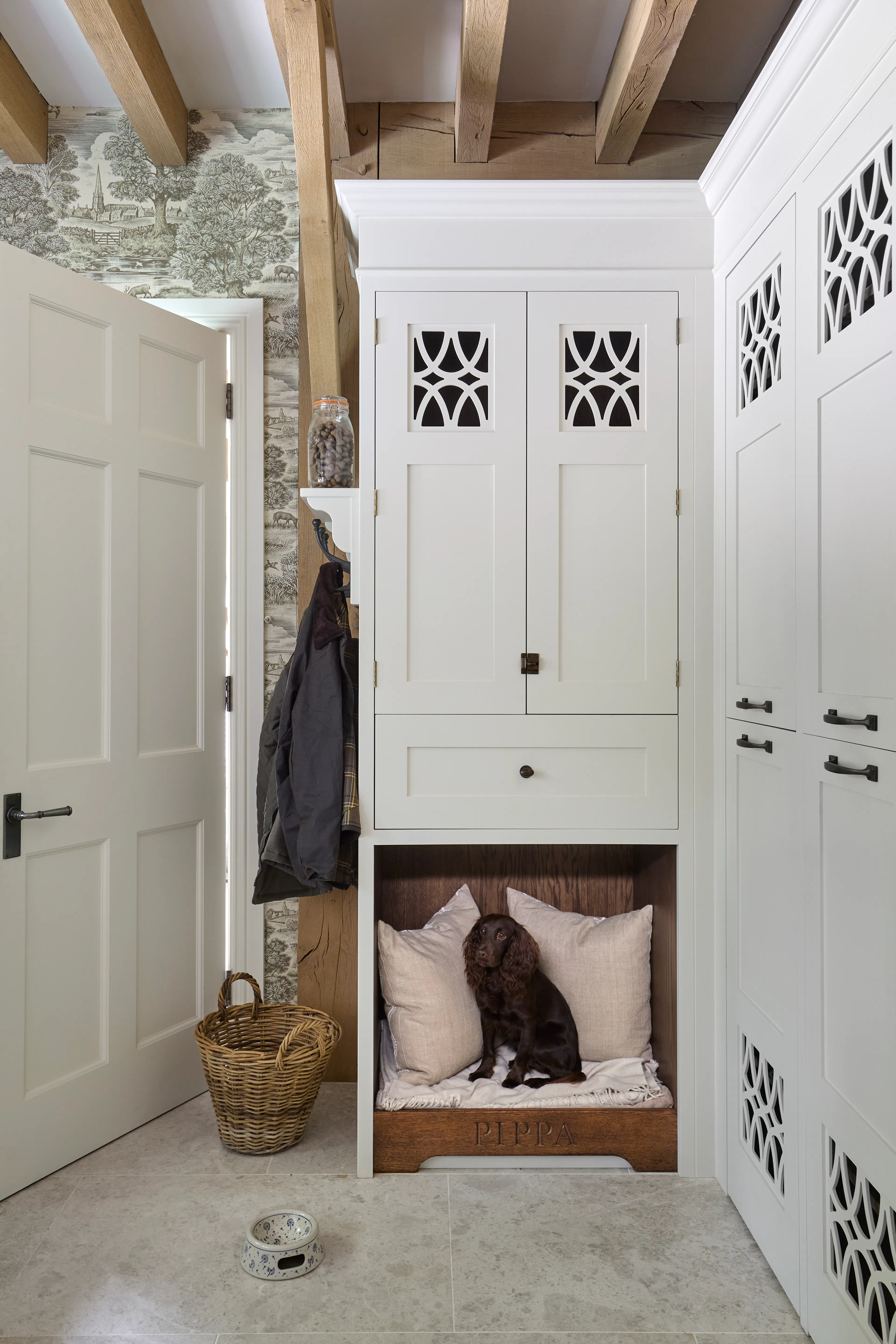 A boot room with built in cupboards and a dog bed in a large 6 bedroom oak framed home