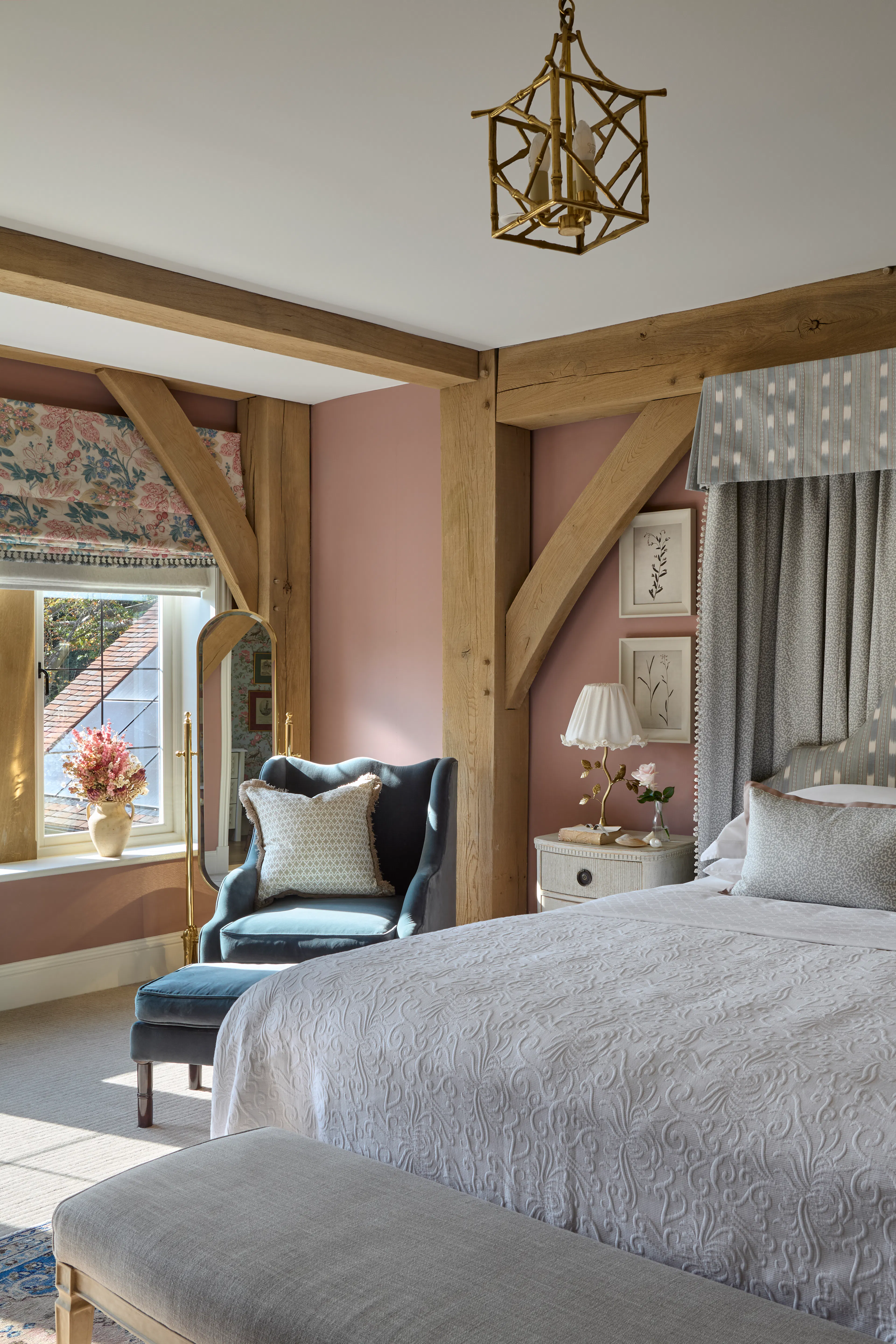 A bedroom with pink painted walls in a large 6 bedroom oak framed home