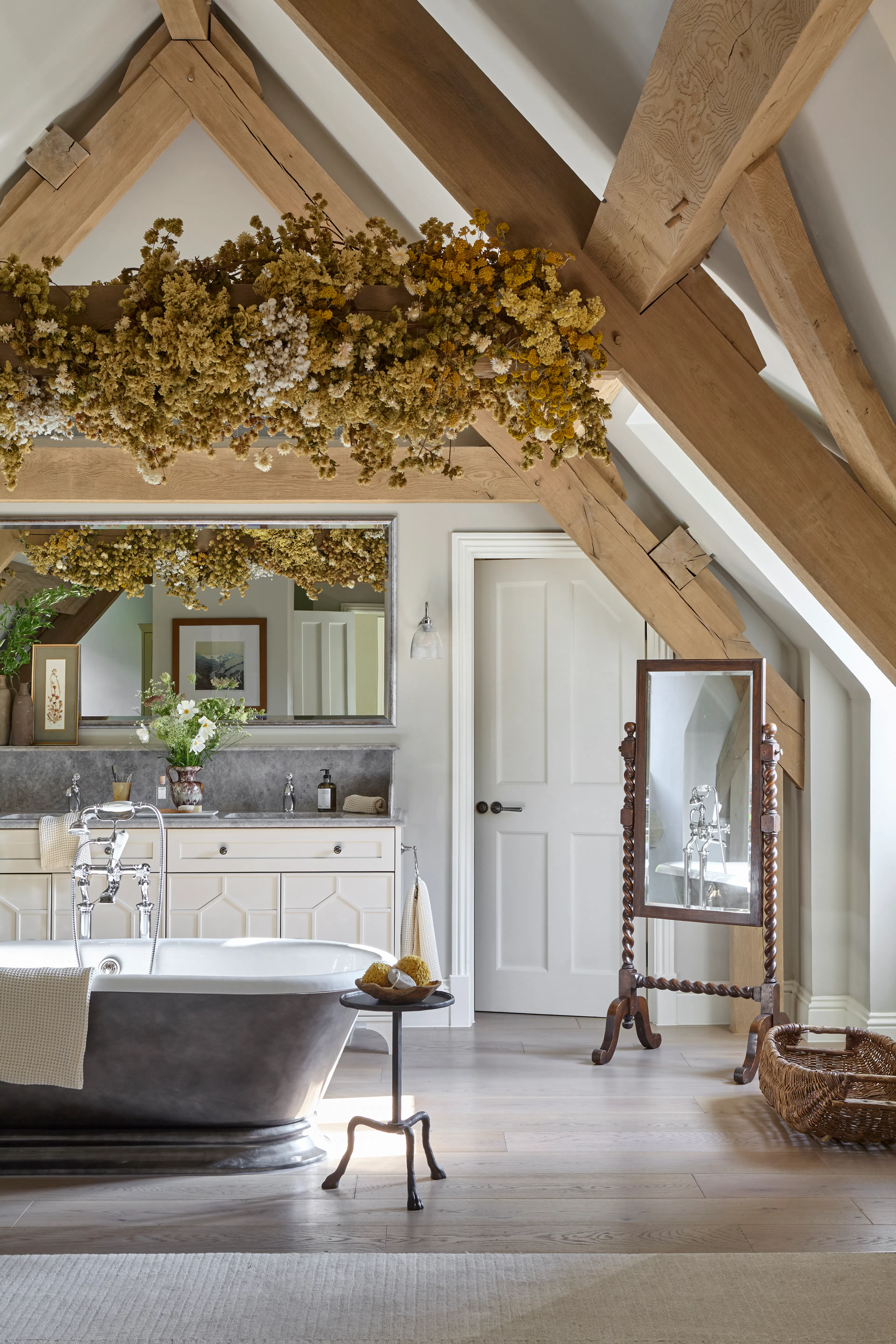 A vaulted ceiling bedroom with a freestanding bath in the loft space of a large 6 bedroom oak framed home