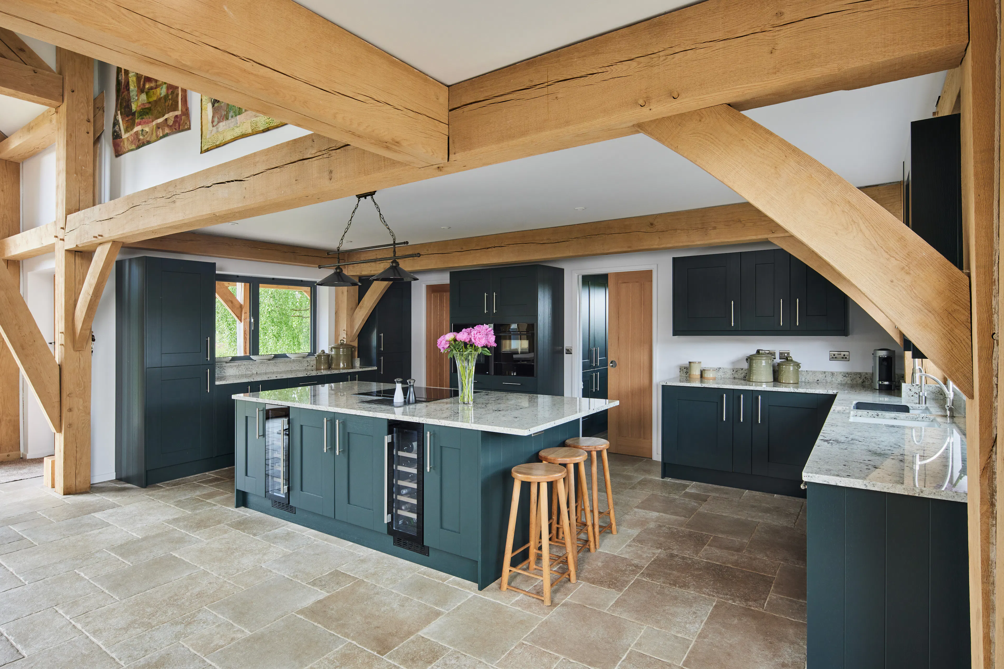 A kitchen with blue cupboards in a large oak framed home