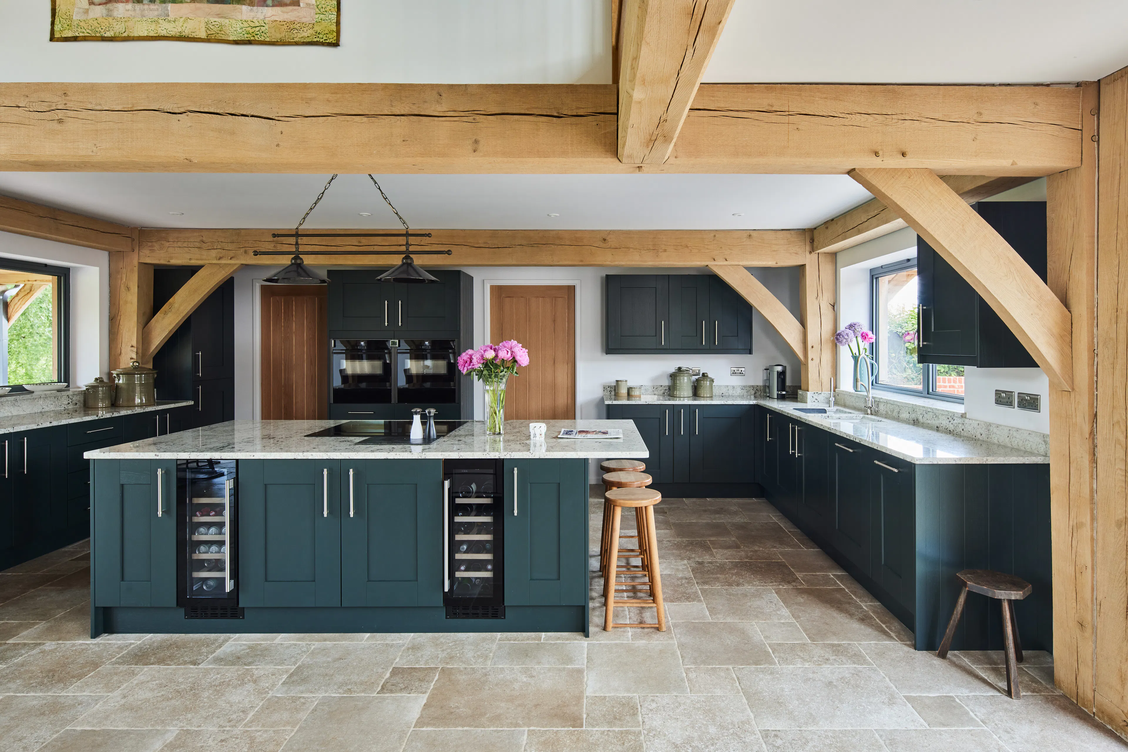 A kitchen with blue cupboards in a large oak framed home