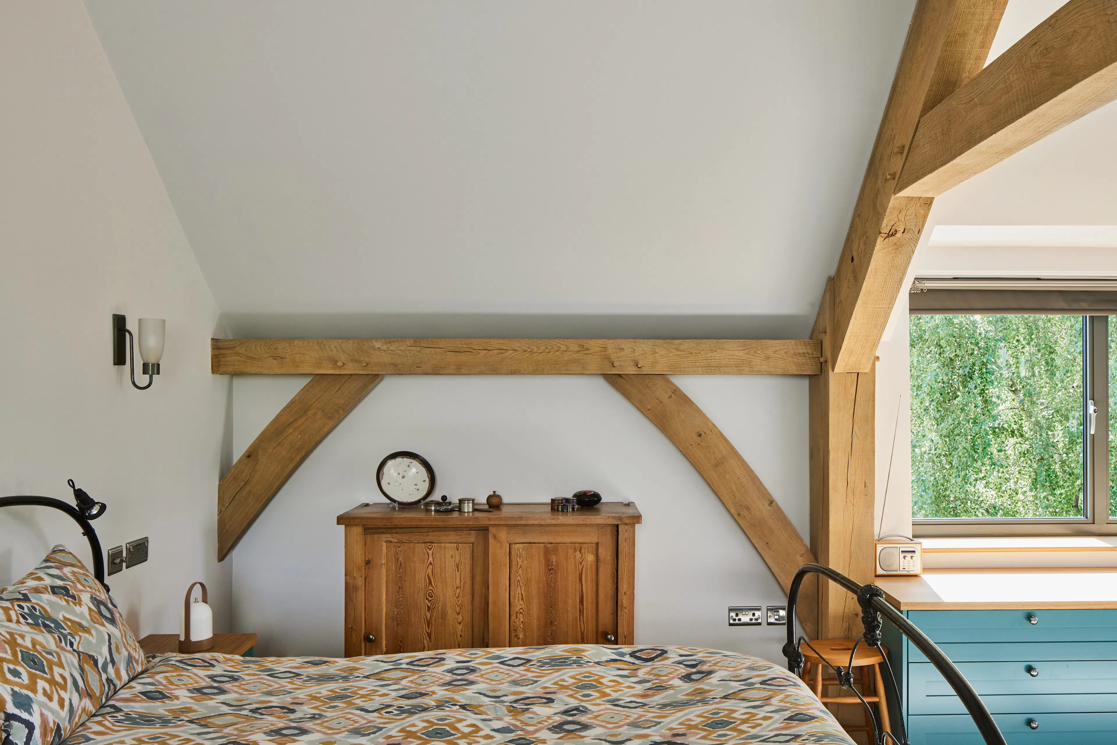 A bedroom with a vaulted ceiling in a large oak framed home