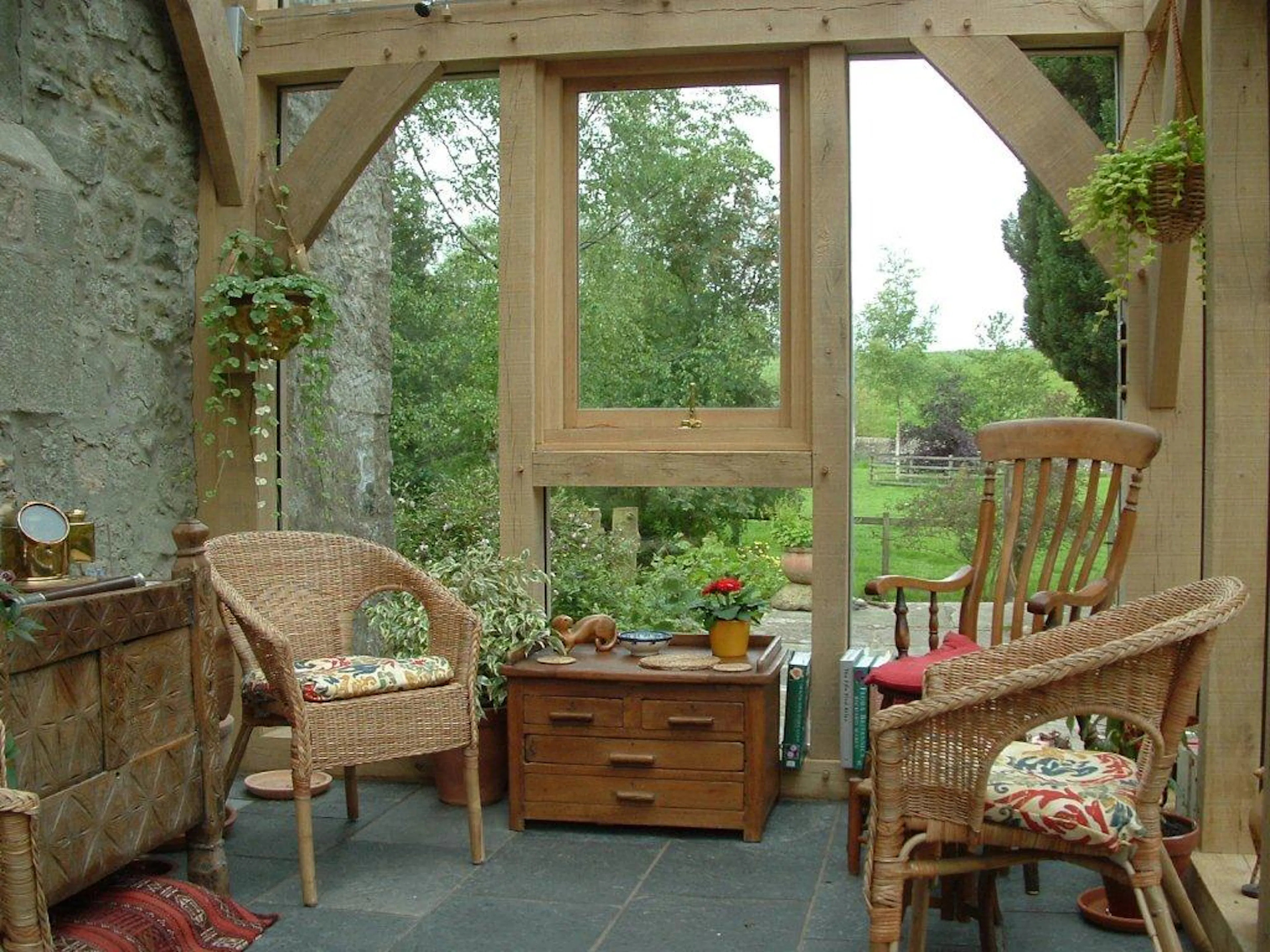 A glazed oak framed sun room or garden room with wooden chairs