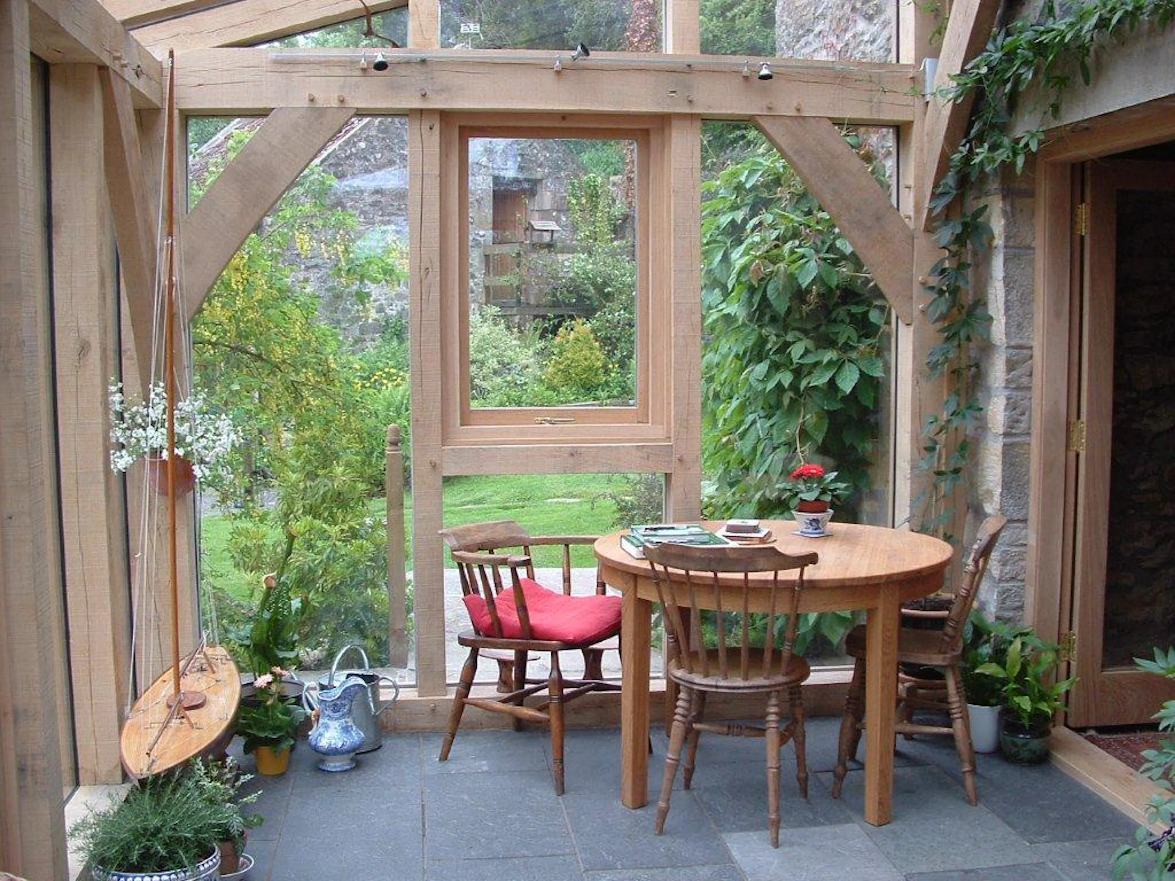 A glazed oak framed sun room or garden room with wooden furniture