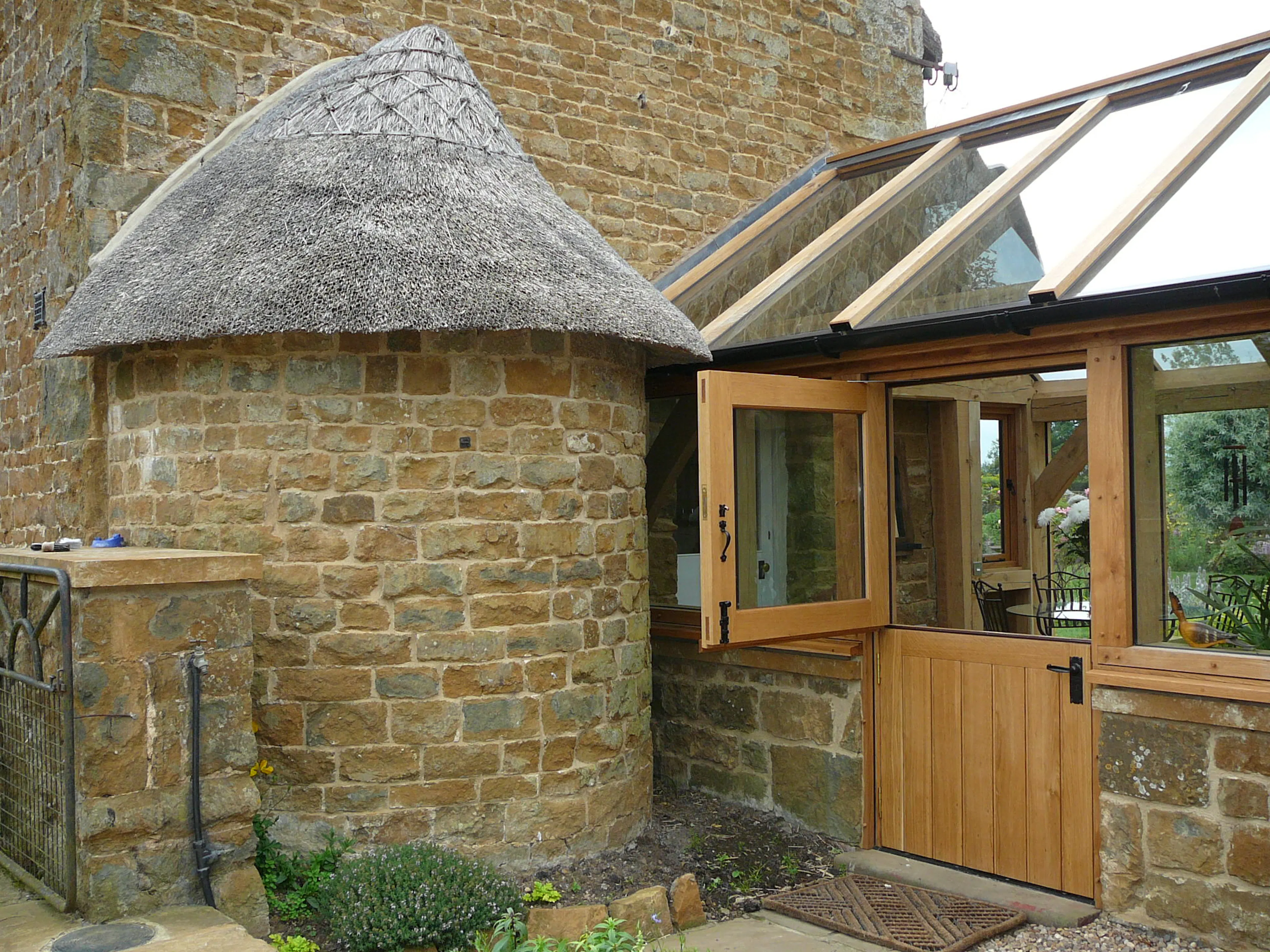 A link extension sunroom to a thatched cottage