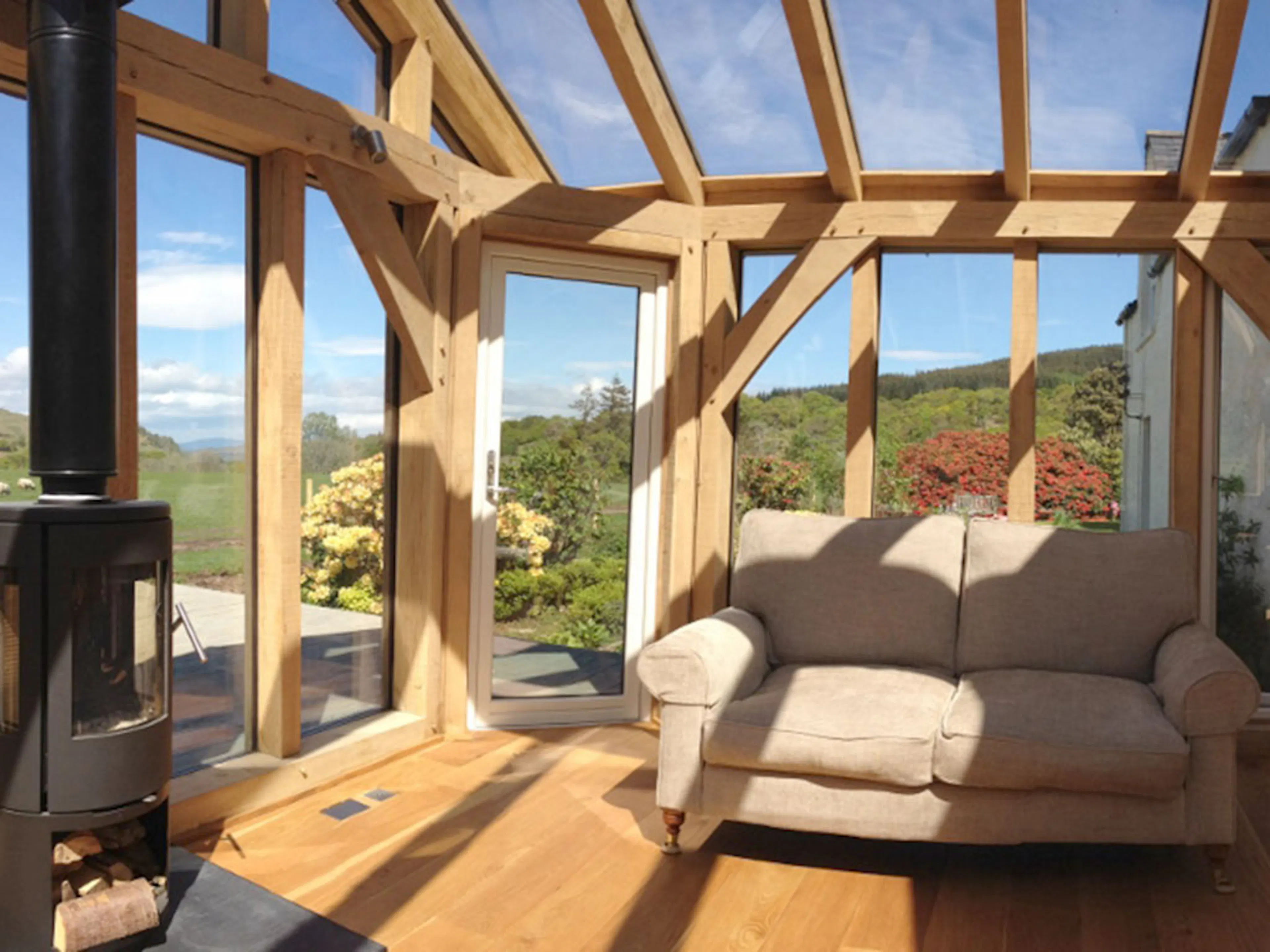An oak framed sun room or garden room with sunlight coming through the glazing