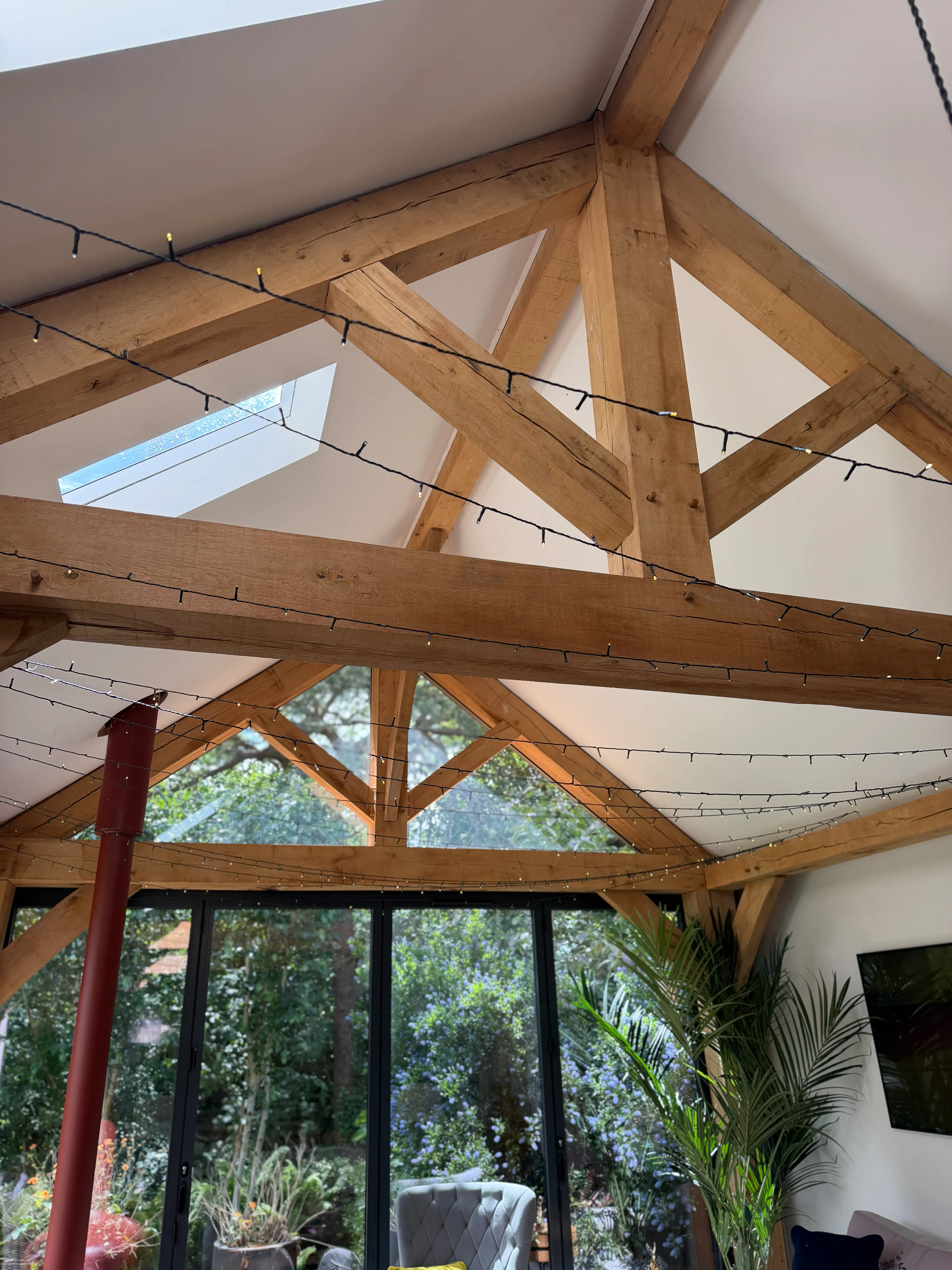 Interior garden room with exposed oak frame construction featuring a king post truss