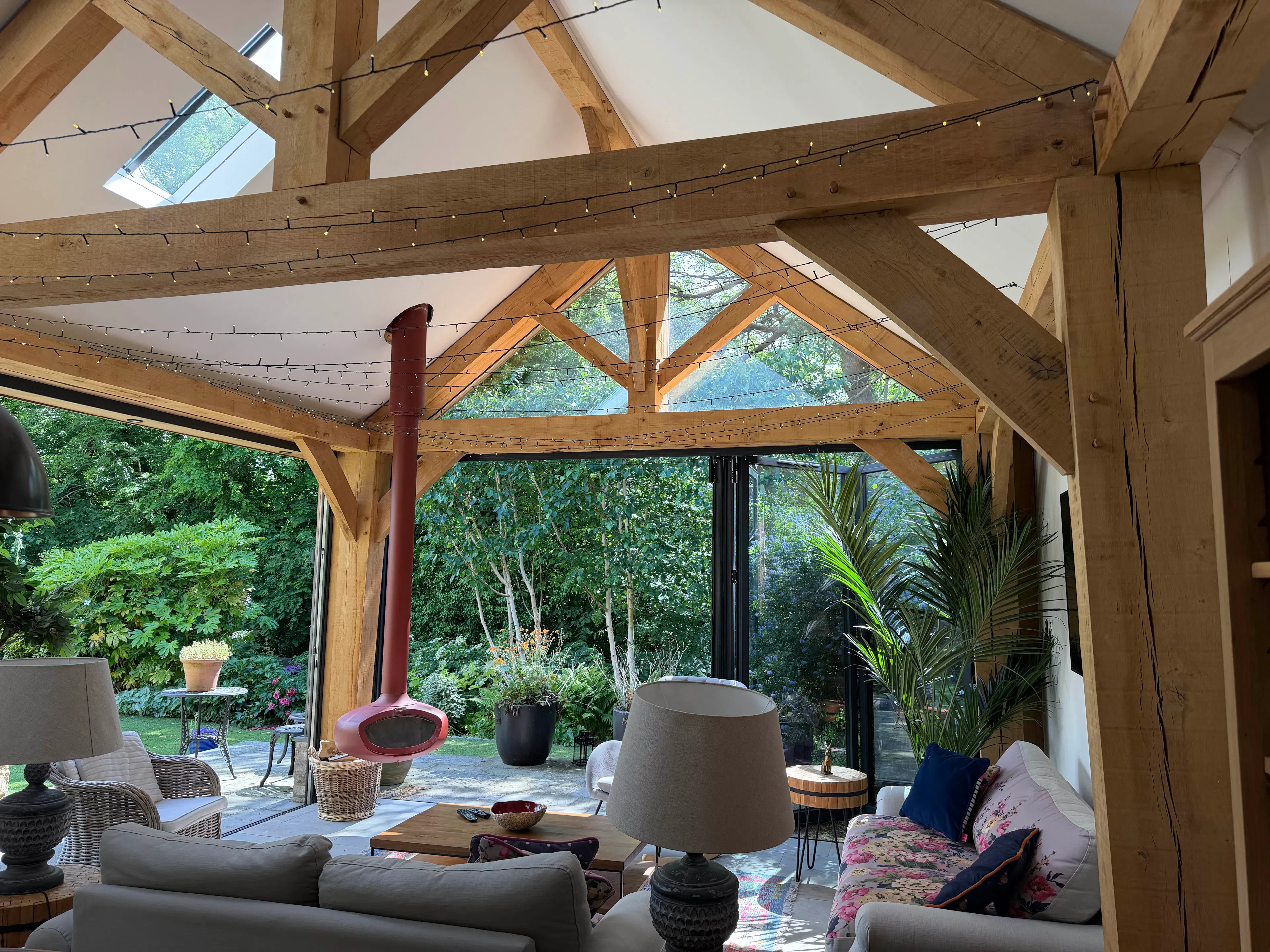 Open-plan garden room interior with exposed oak frame construction, creating a bright and spacious living area