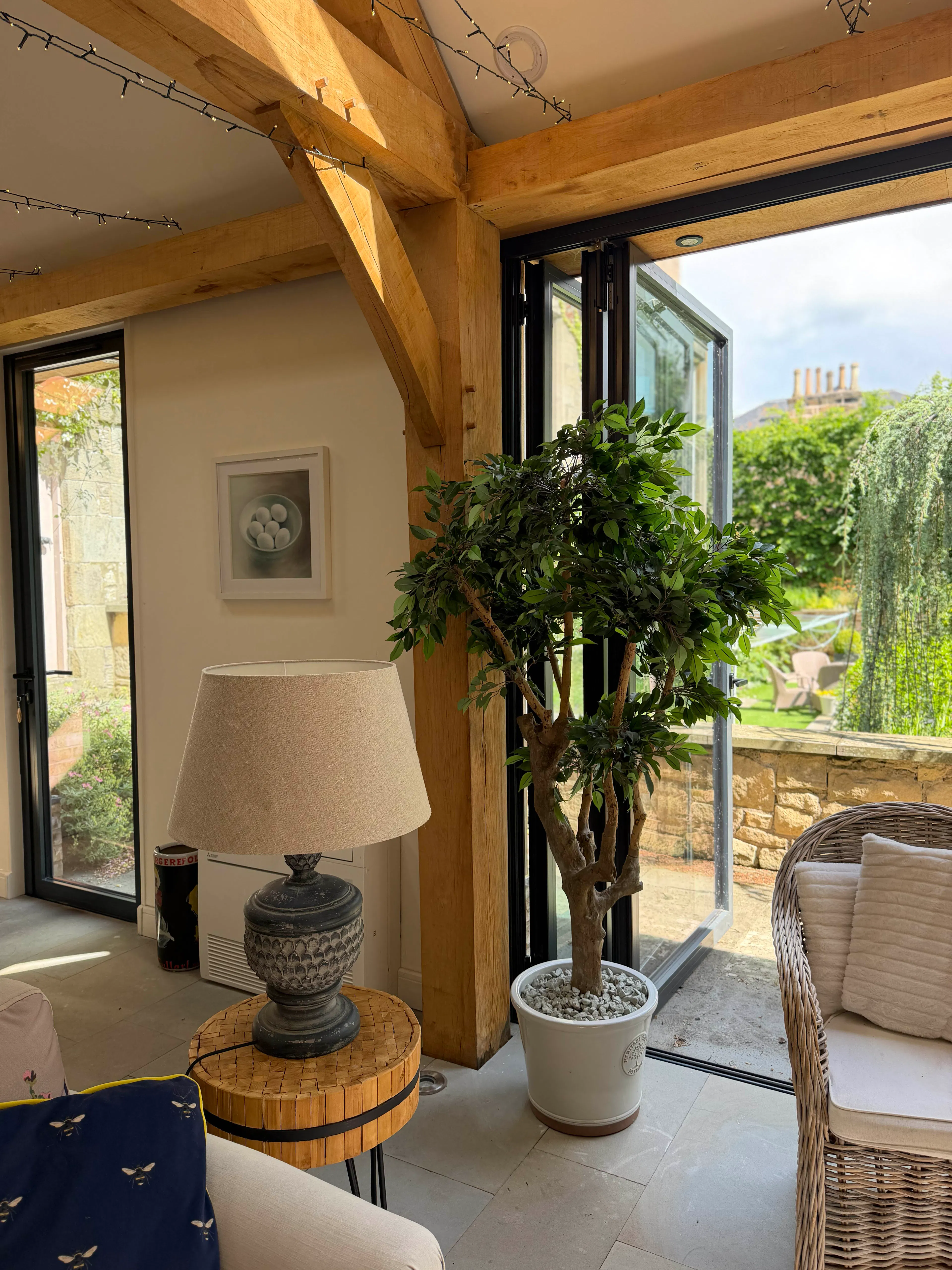 Interior view of a garden room with exposed oak frame construction and structural posts, highlighting the timber framing details within the space