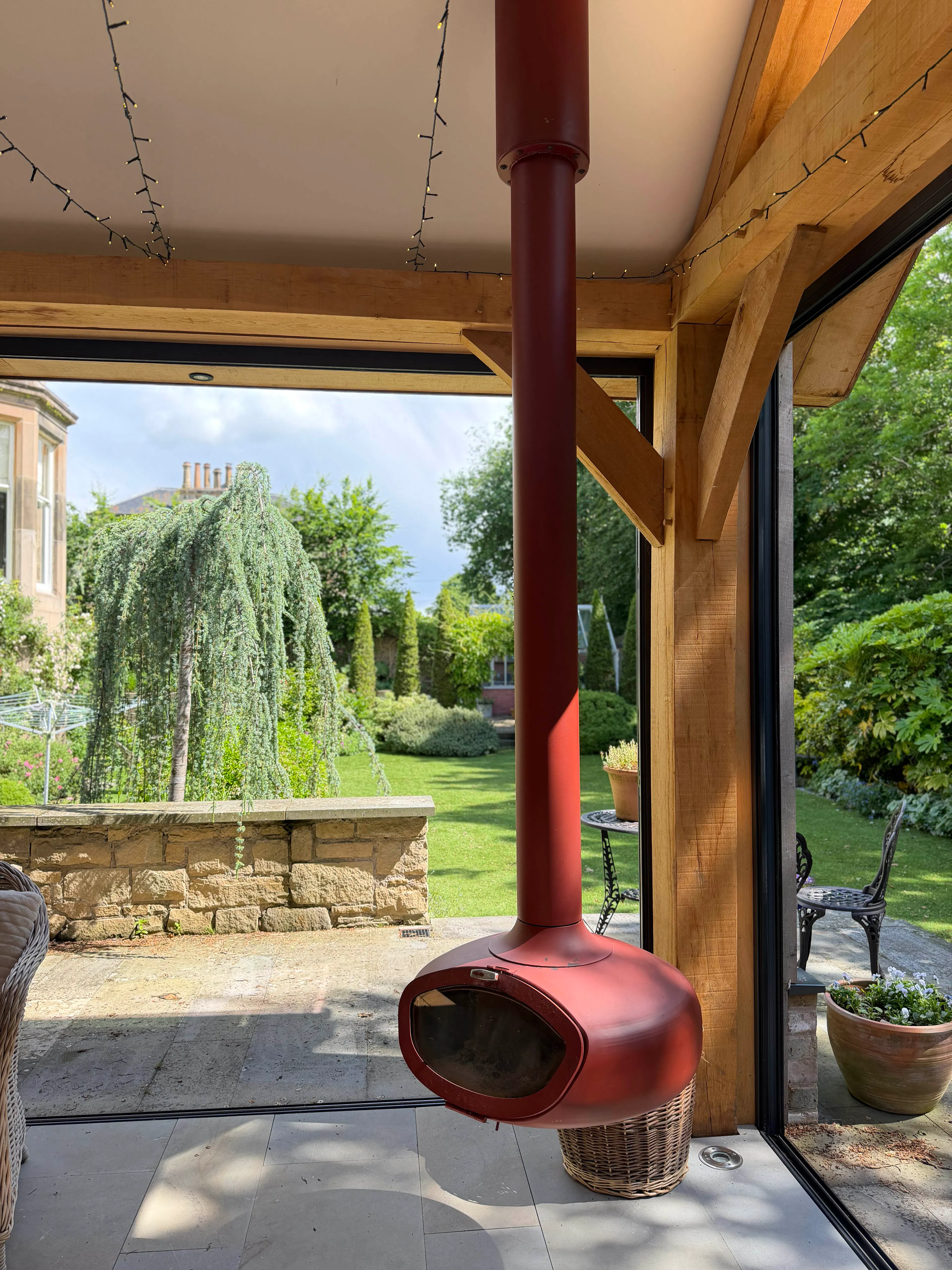 Garden room interior with exposed oak frame, featuring a wall brace, fireplace, and a bright living space with natural timber detailing