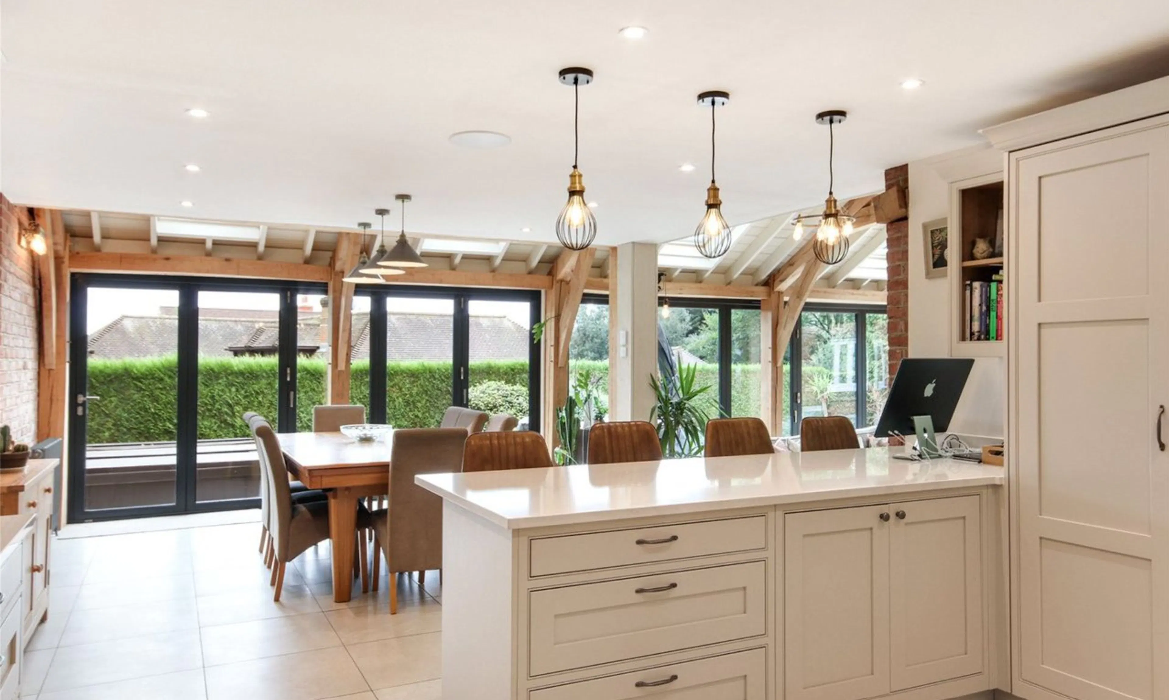A modern oak framed extension encompassing an open plan kitchen and dining area with integrated glazing and roof lights providing lots of natural light.