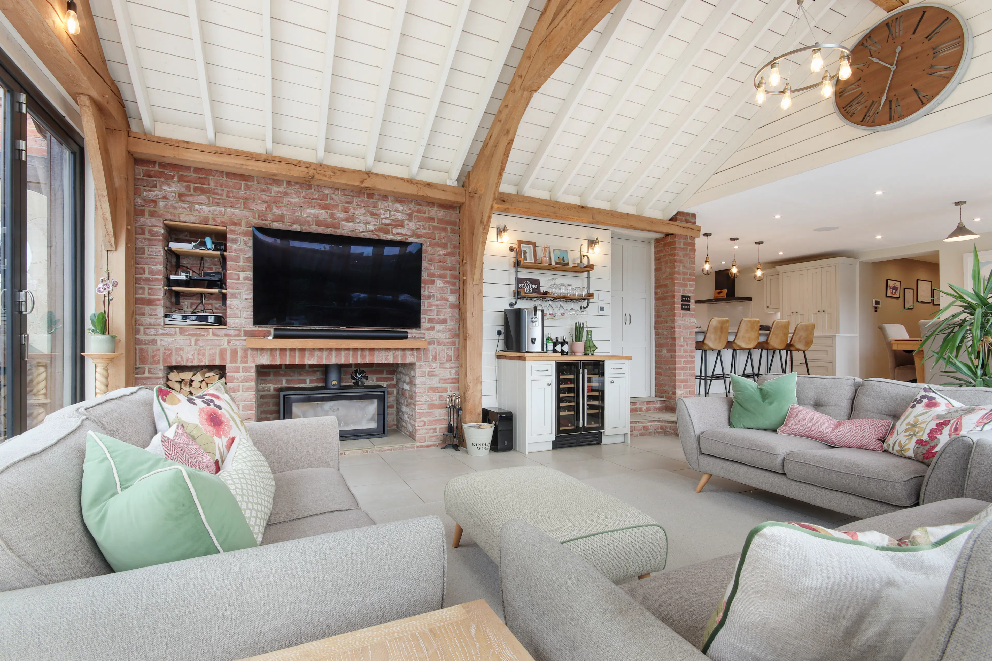 A modern oak framed extension encompassing an open plan family room with white roof boarding.