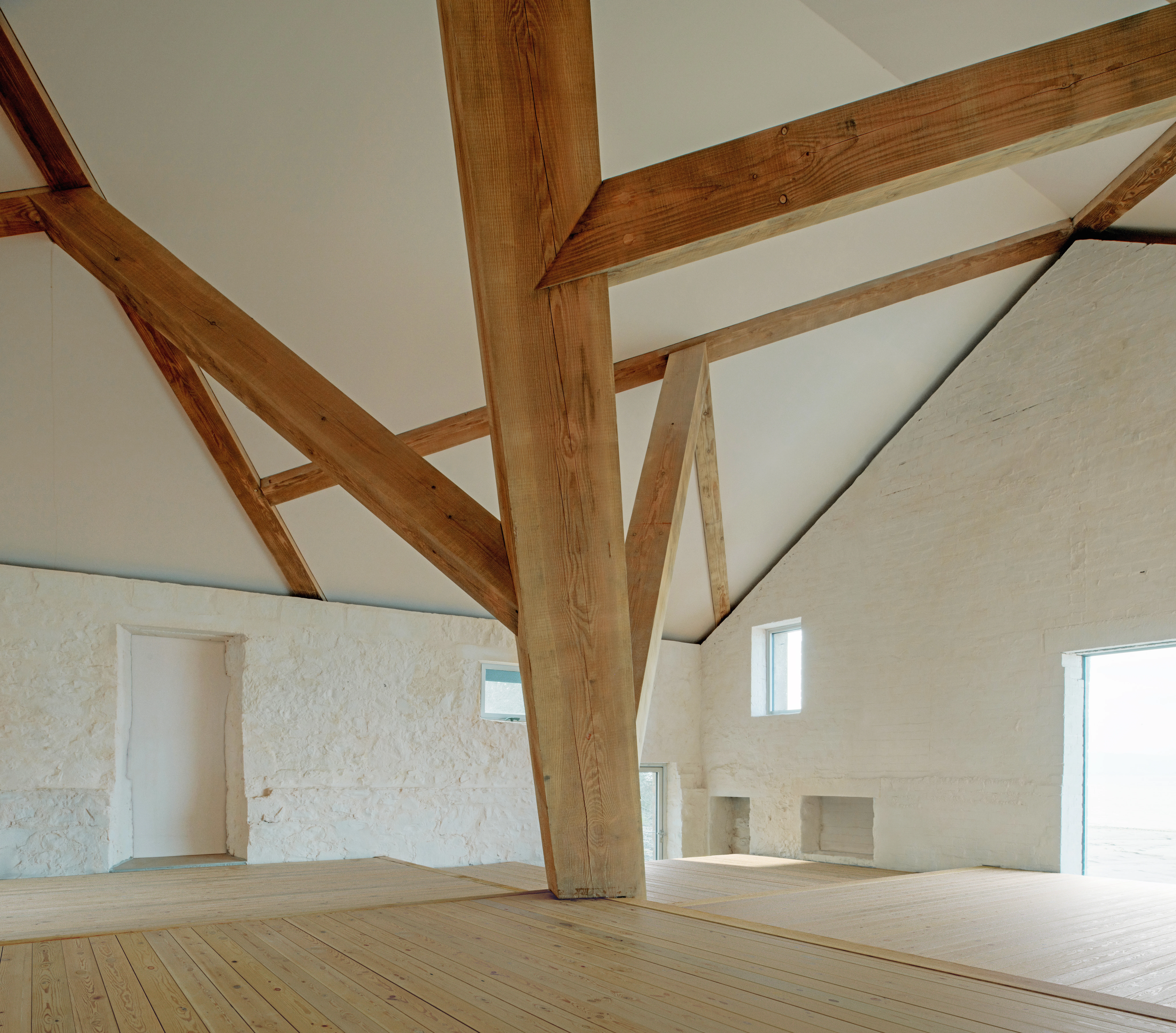 Interior of a riverside boathouse with a complex structural timber frame