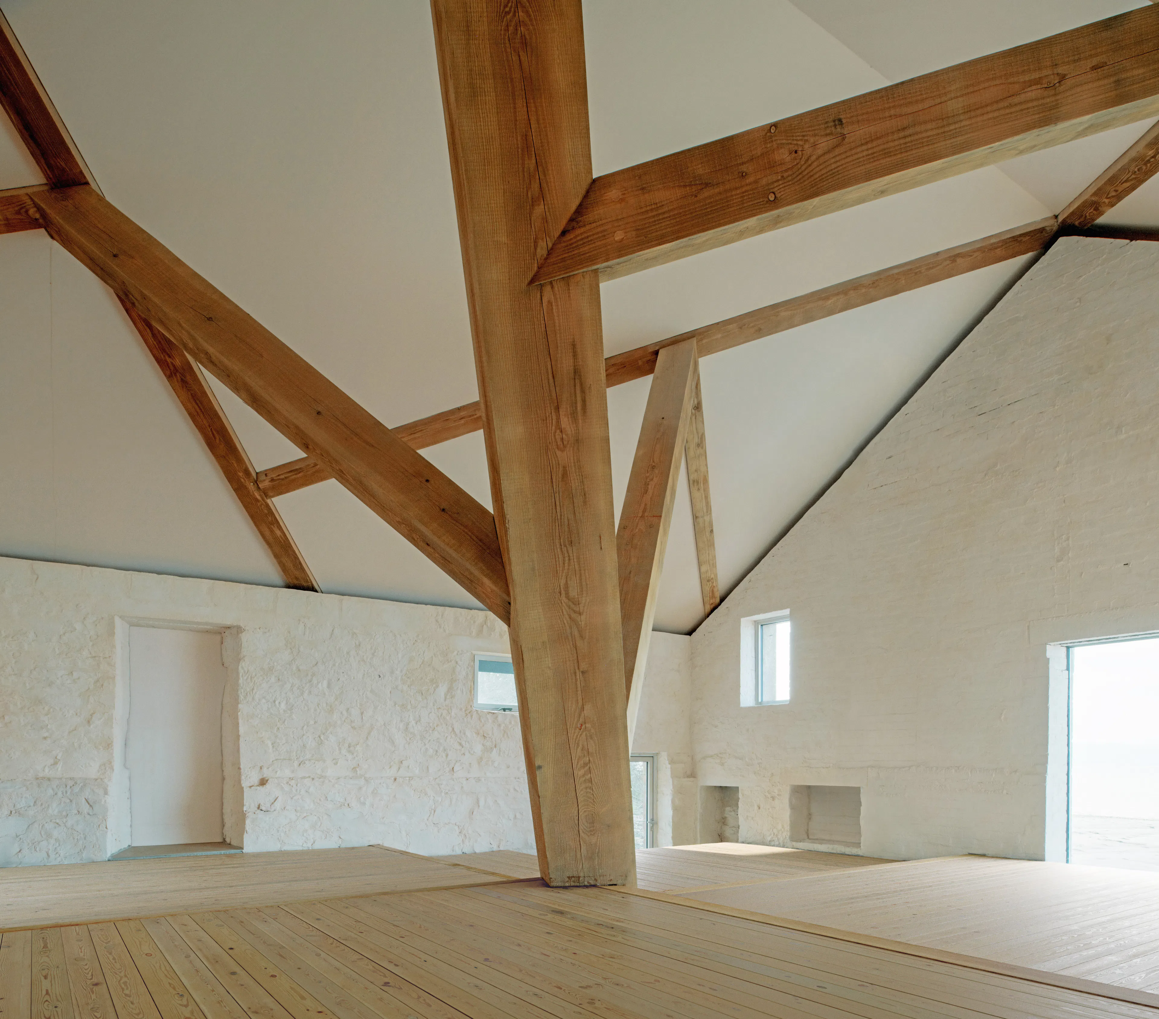 Interior of a riverside boathouse with a complex structural timber frame