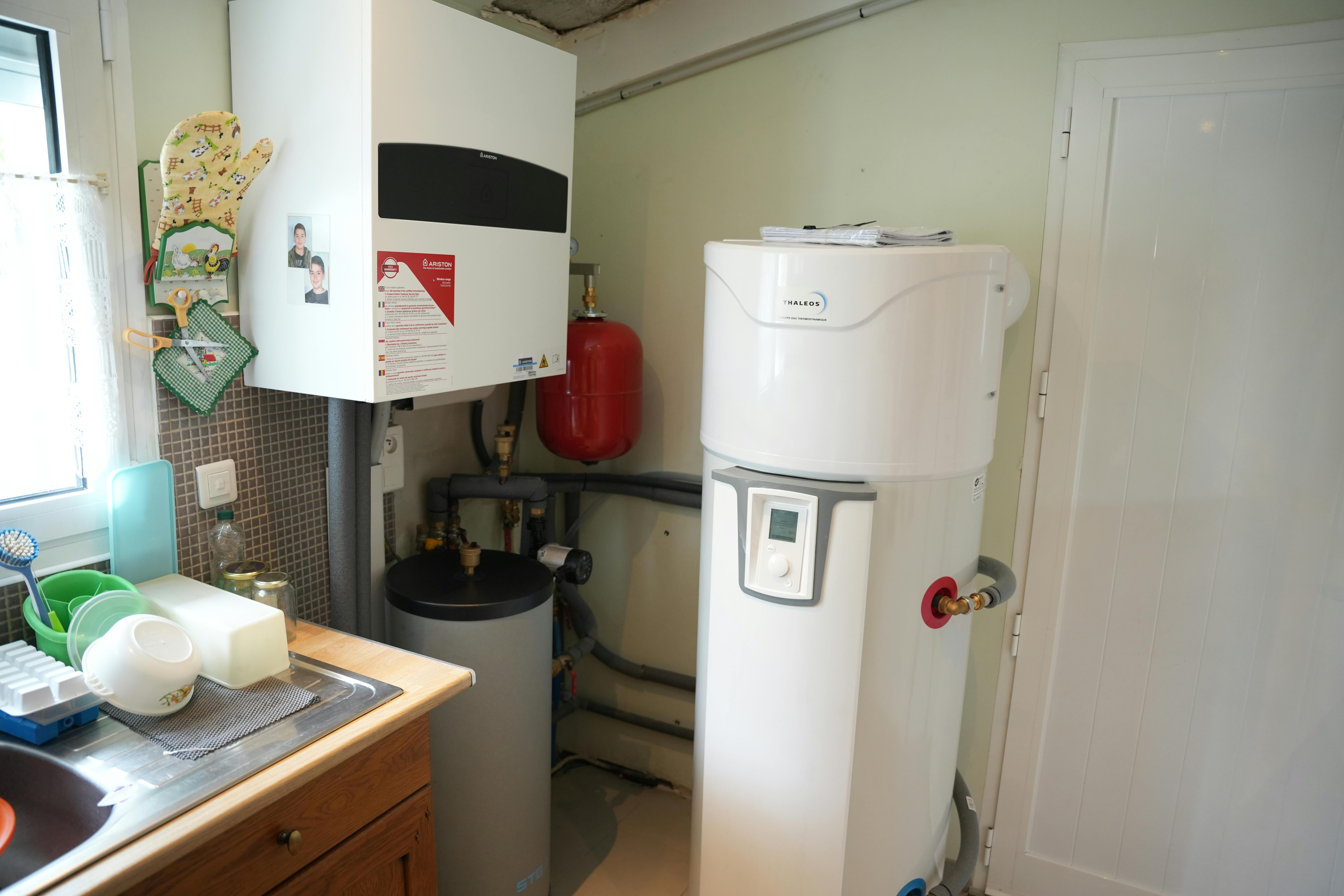 Photo de l'installation d'un ballon thermodynamique à l'intérieur d'une maison, qui complète l'installation de la pompe à chaleur