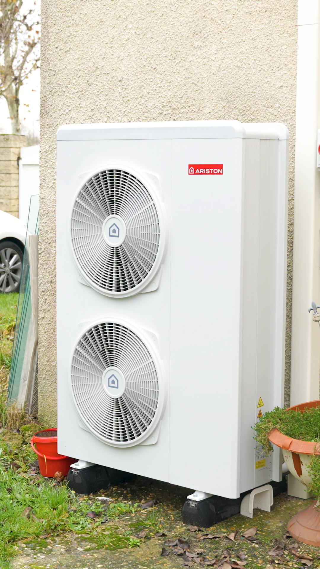 Pompe à chaleur air eau de marque Ariston installée sur mur maison