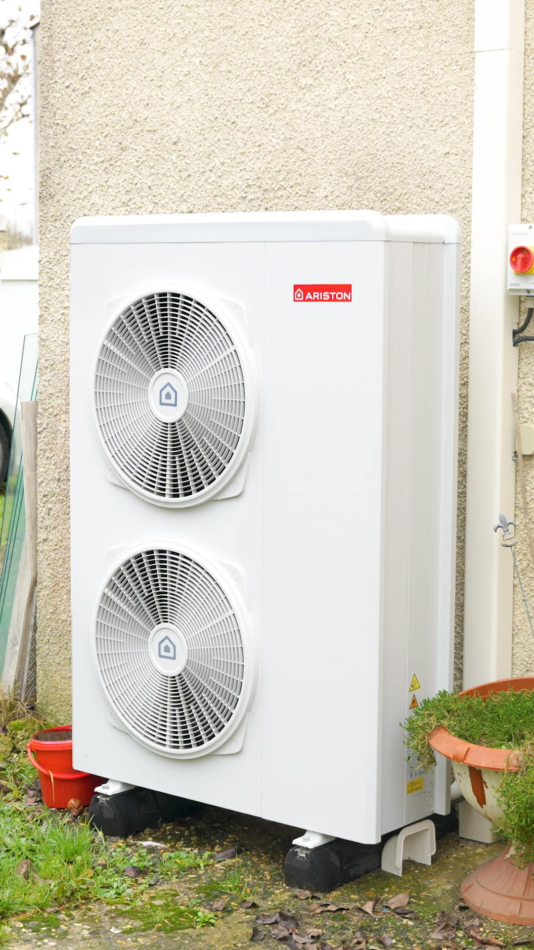 Pompe à chaleur air eau de marque Ariston installée sur mur maison