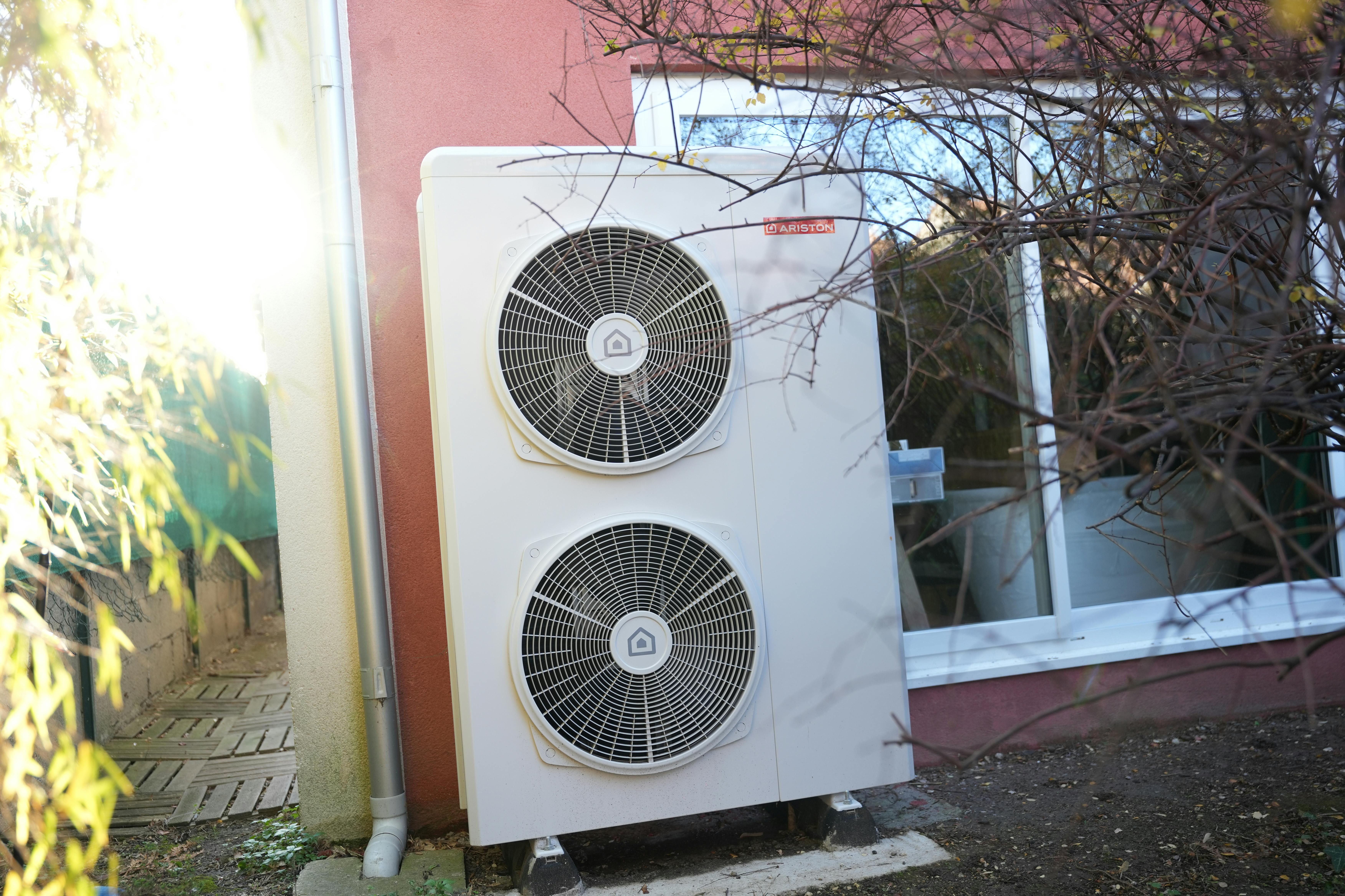 Pompe à chaleur air eau de marque Ariston nimbus installée sur façade mur maison