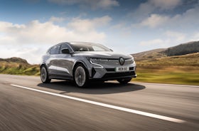 White Renault Megane Etech Electric driving on country roads.