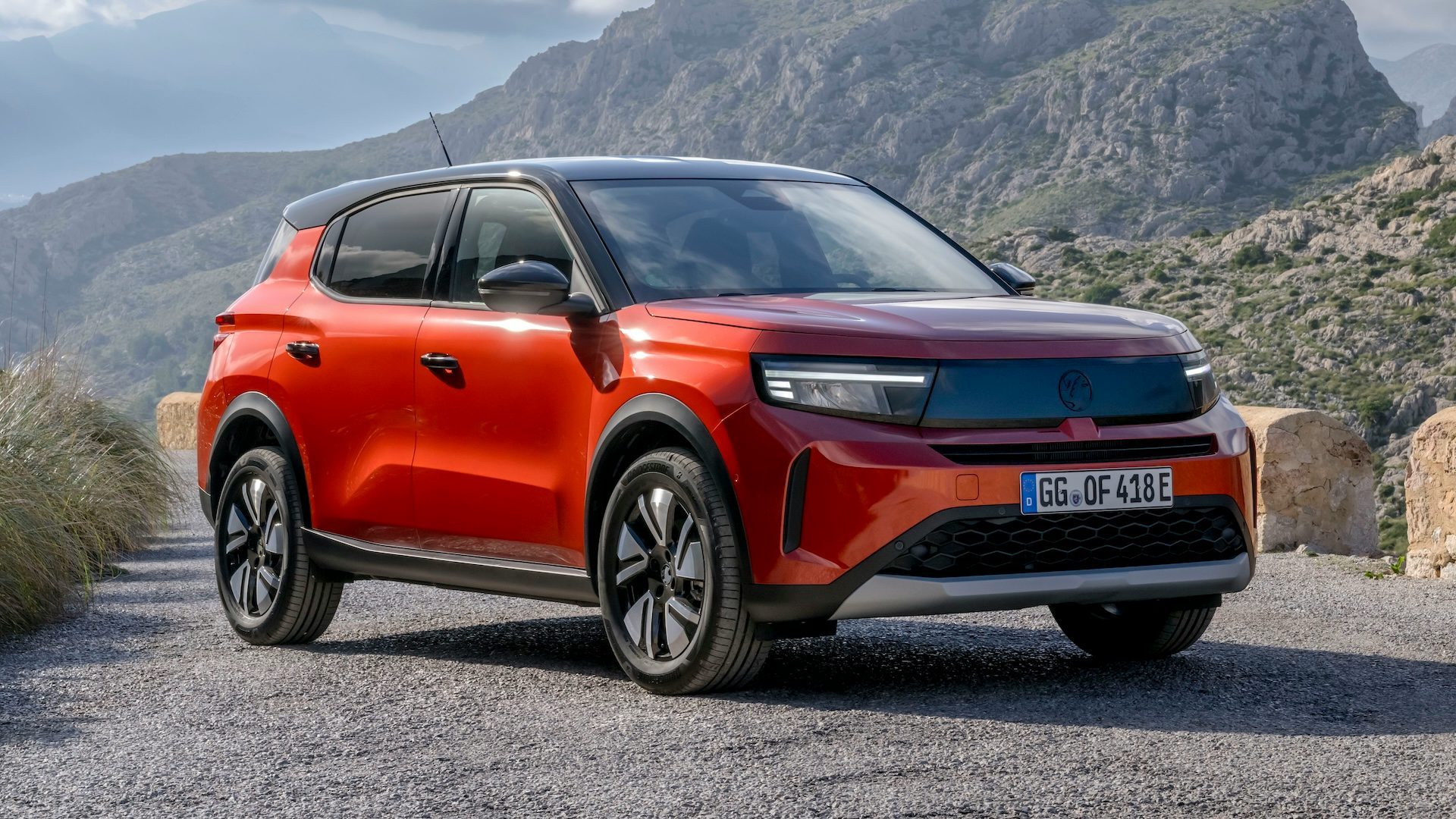 Orange 2024 Vauxhall Frontera Electric in the mountains, front quarter static angle.