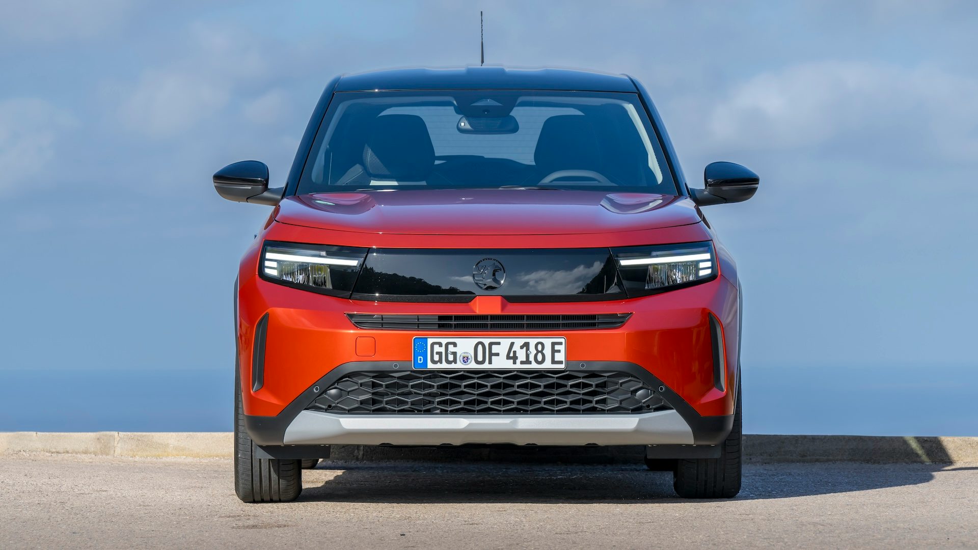 Orange 2024 Vauxhall Frontera Electric parked, front view.