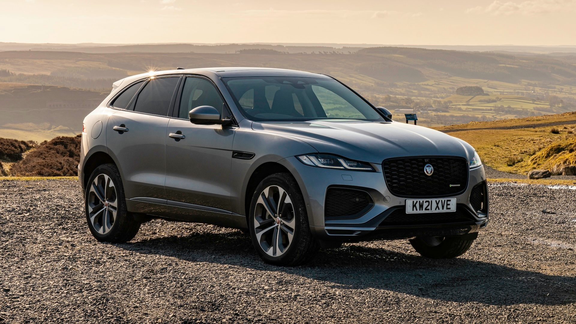 Silver 2021 Jaguar F-Pace parked on gravel, front quarter view.