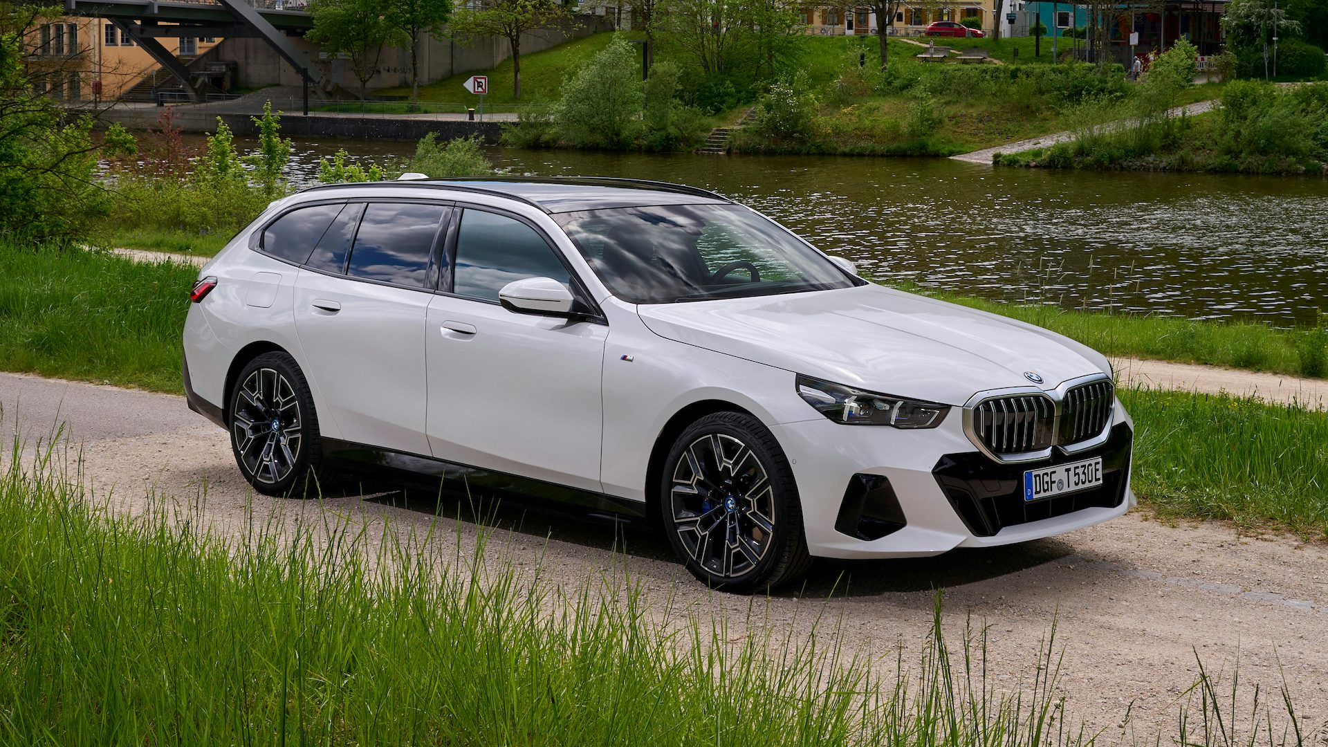 White 2024 BMW 5 Series Touring parked, front quarter.