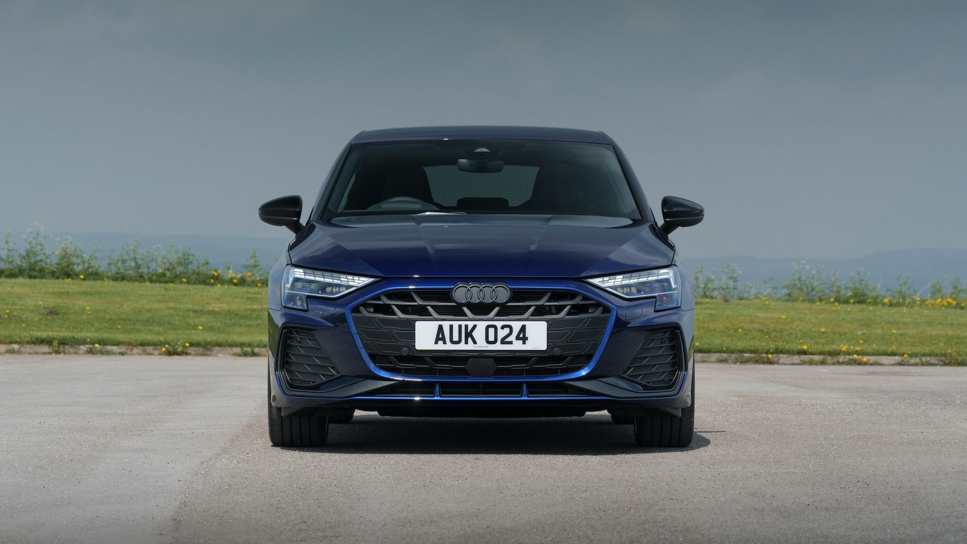Blue 2024 Audi A3 parked in the countryside, front view.
