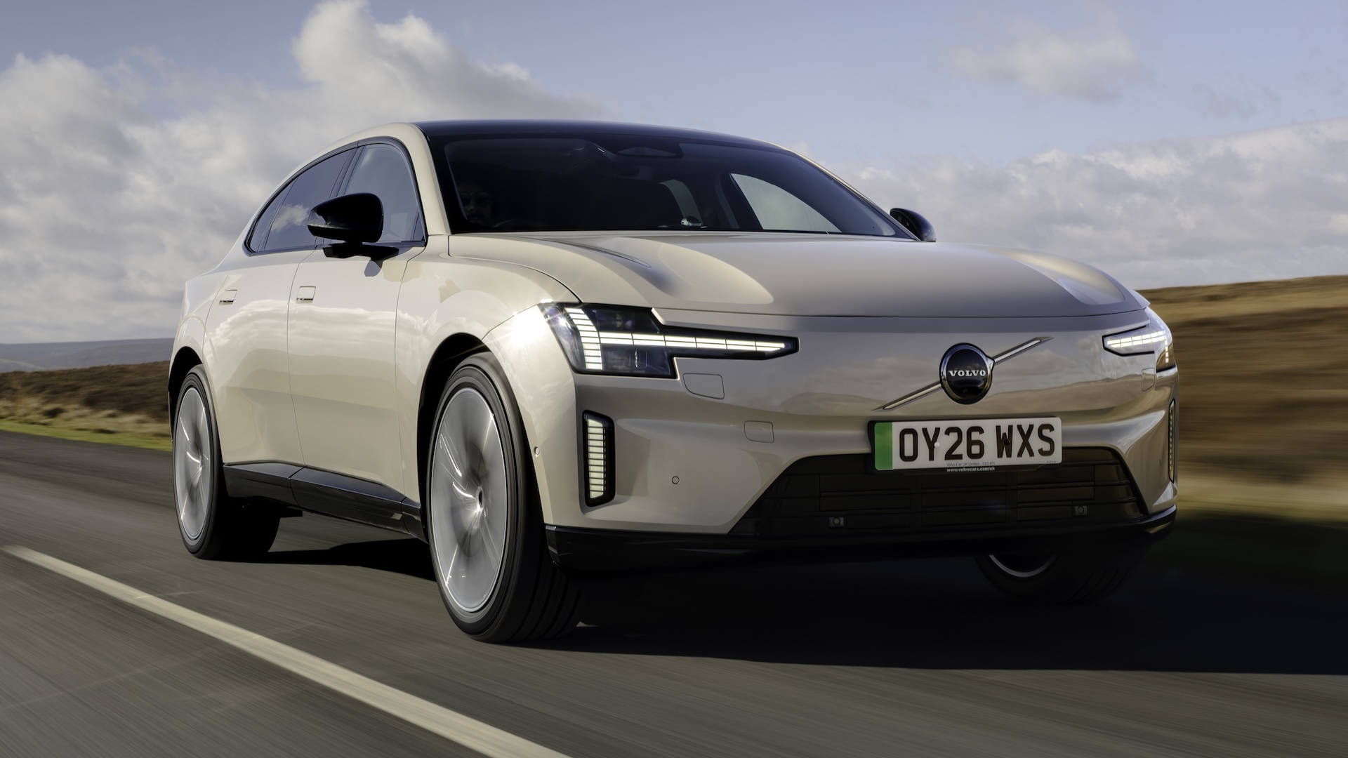 2026 Volvo ES90 driving on a country road, front quarter.