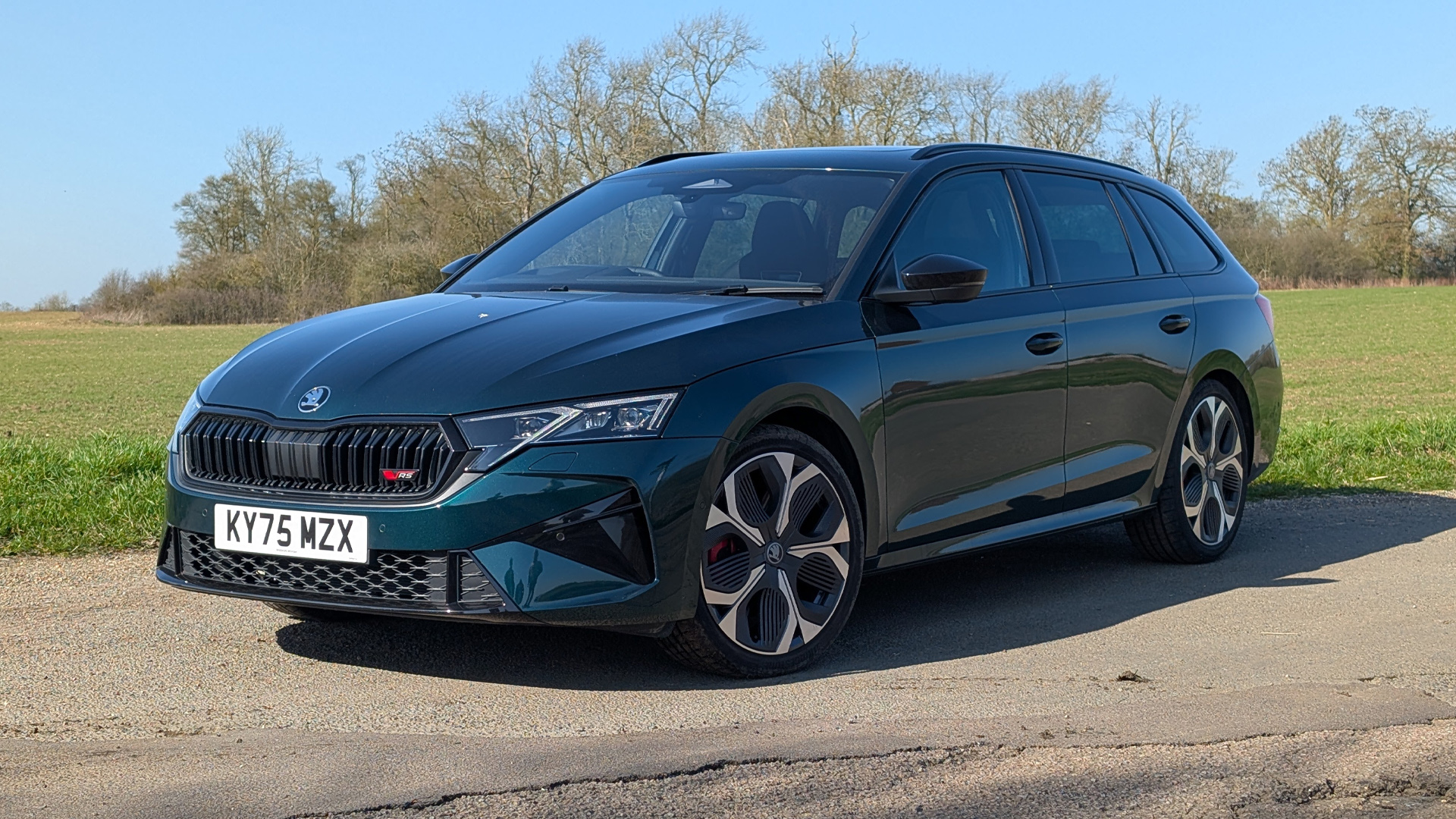 Green RHD 2026 Skoda Octavia vRS Estate front static parked in front of a field