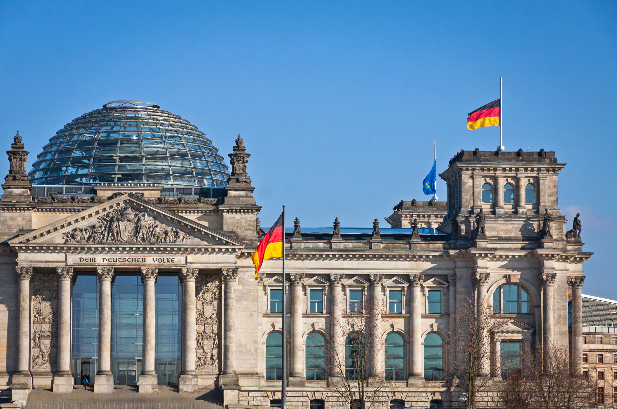 Reichstagsgebäude in Berlin mit Glaskuppel sowie deutscher und europäischer Flagge