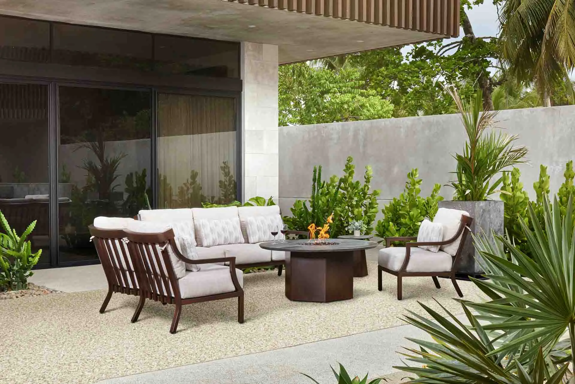 Patio seating area with fire table and cushioned lounge chairs.