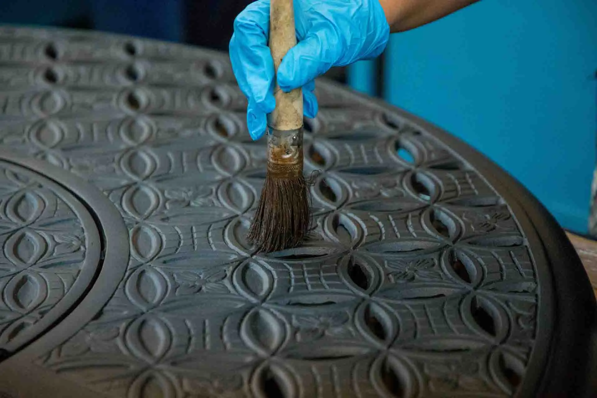 Artisan perfecting furniture in factory setting.