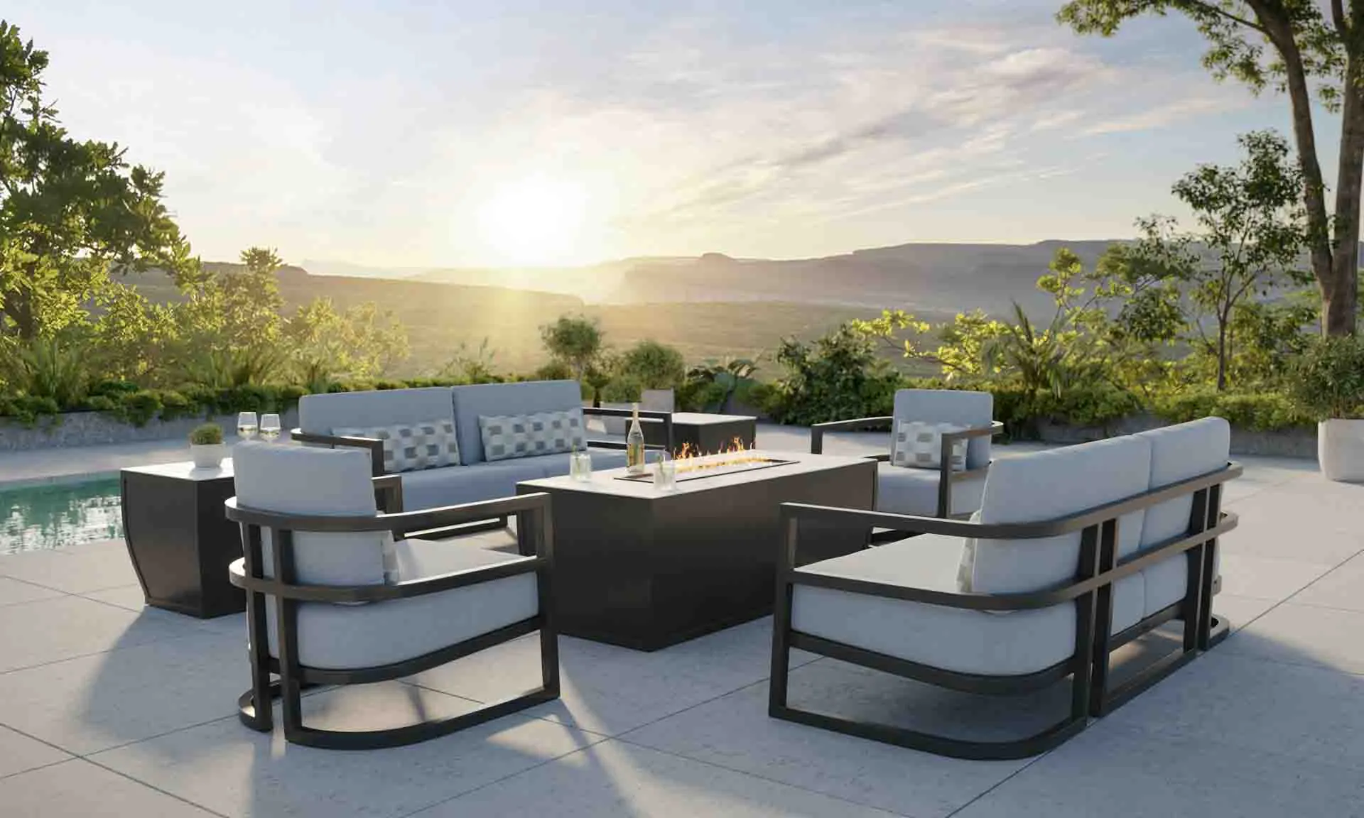 Outdoor poolside lounge area with fire table in mountainside setting.